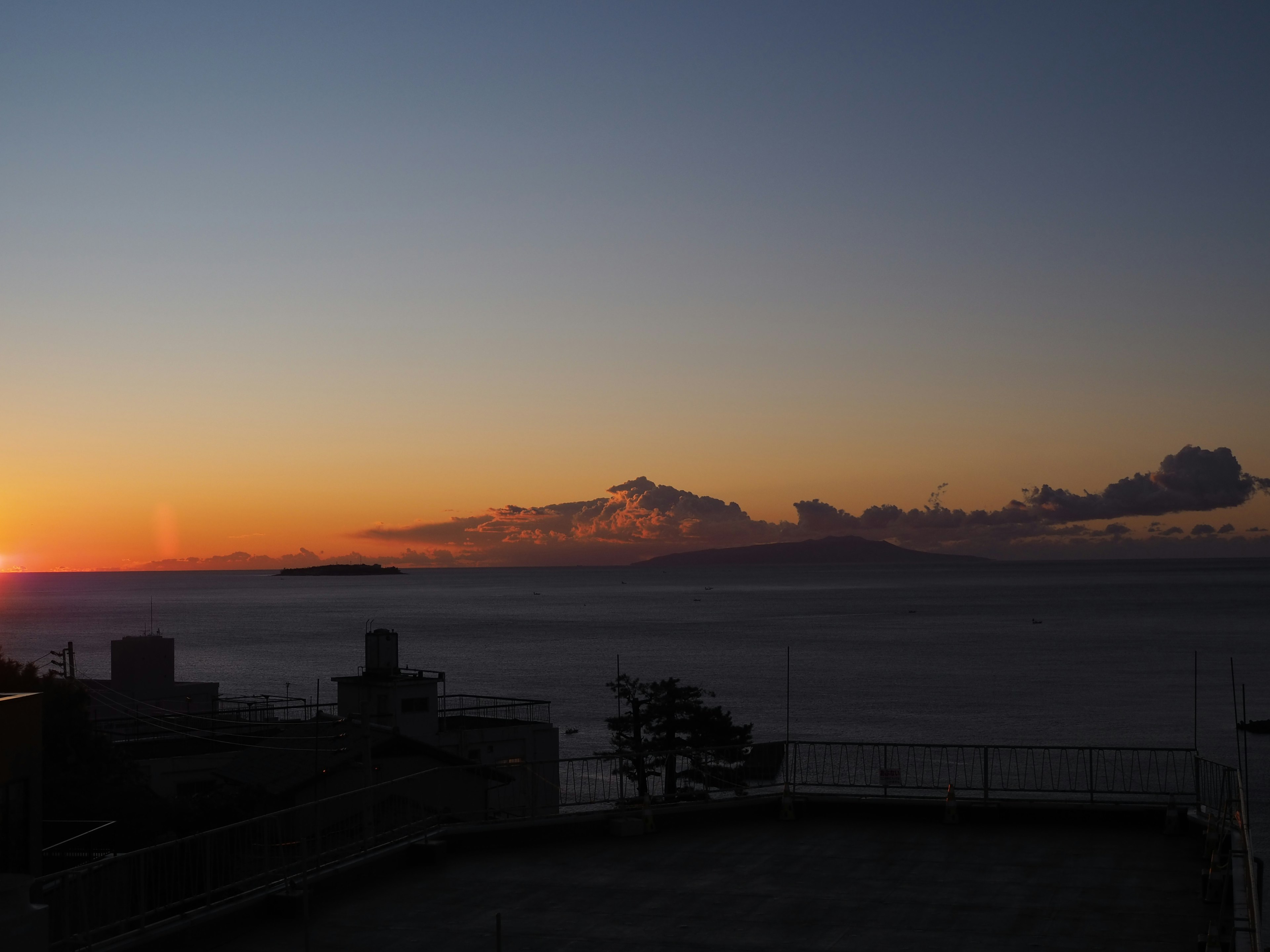 Wunderschöner Sonnenuntergang über dem Ozean mit Bergsilhouetten