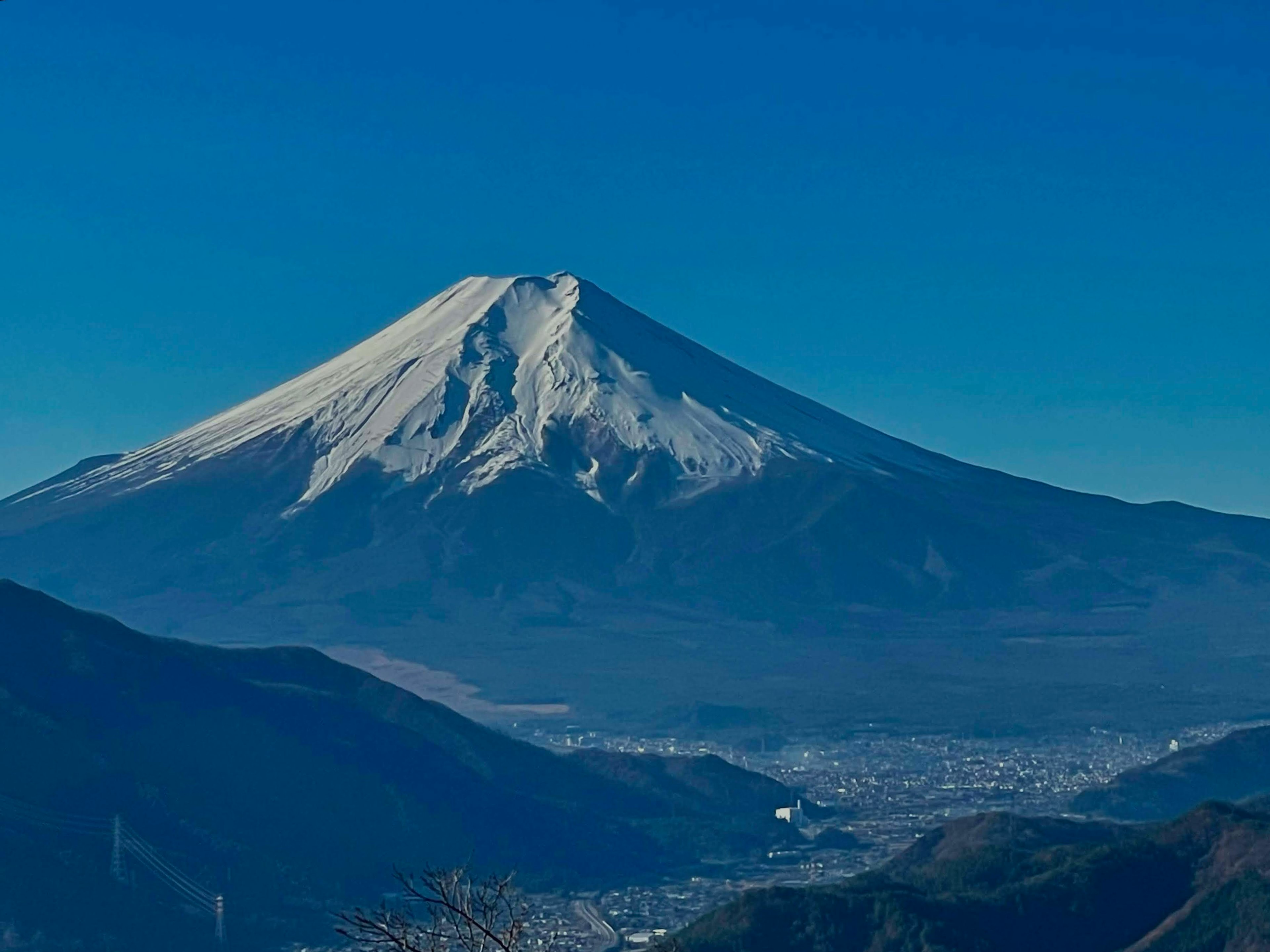 Picco innevato del Monte Fuji contro un cielo blu chiaro