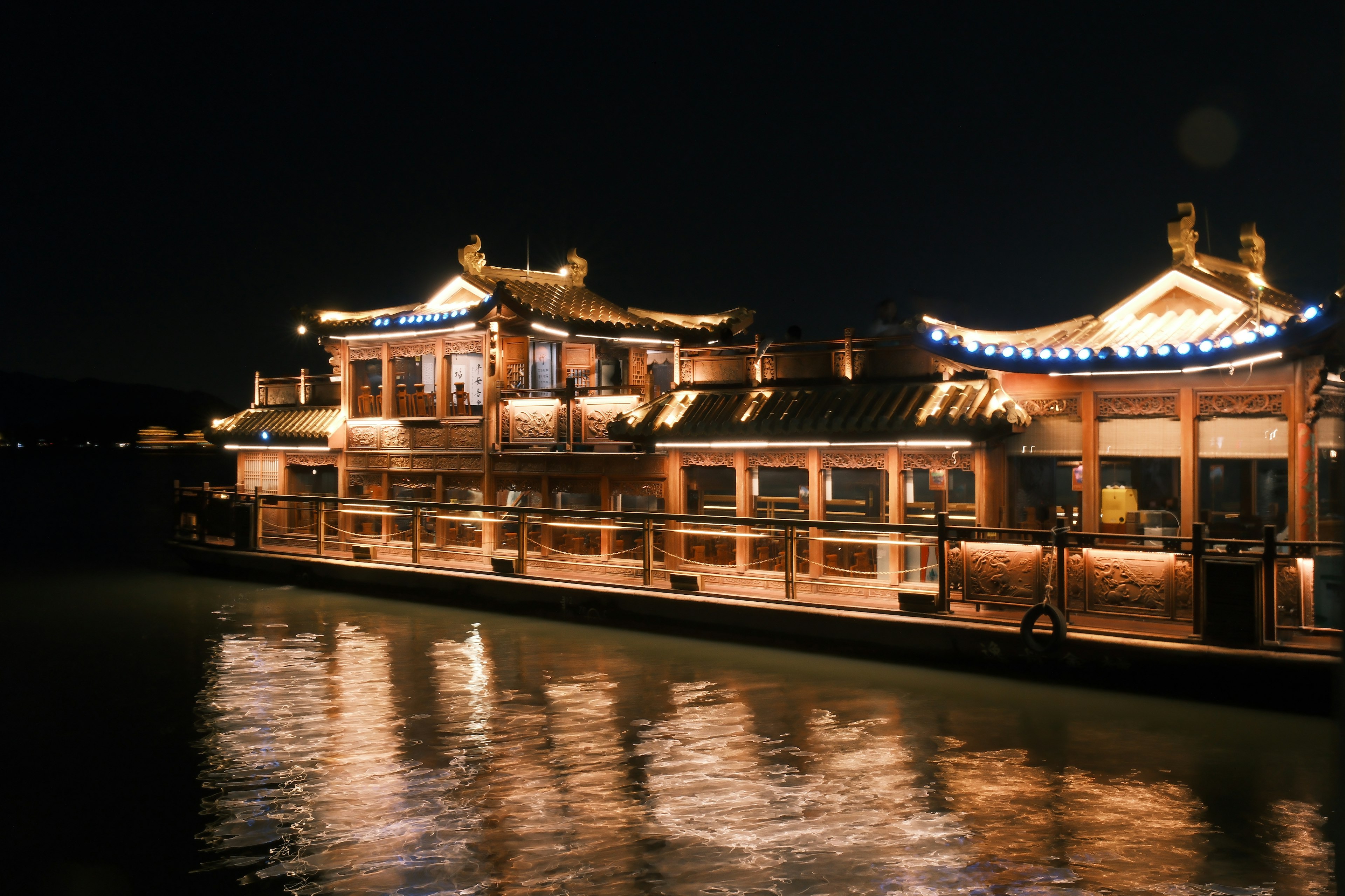 Bâtiment de style chinois traditionnel illuminé la nuit se reflétant sur l'eau