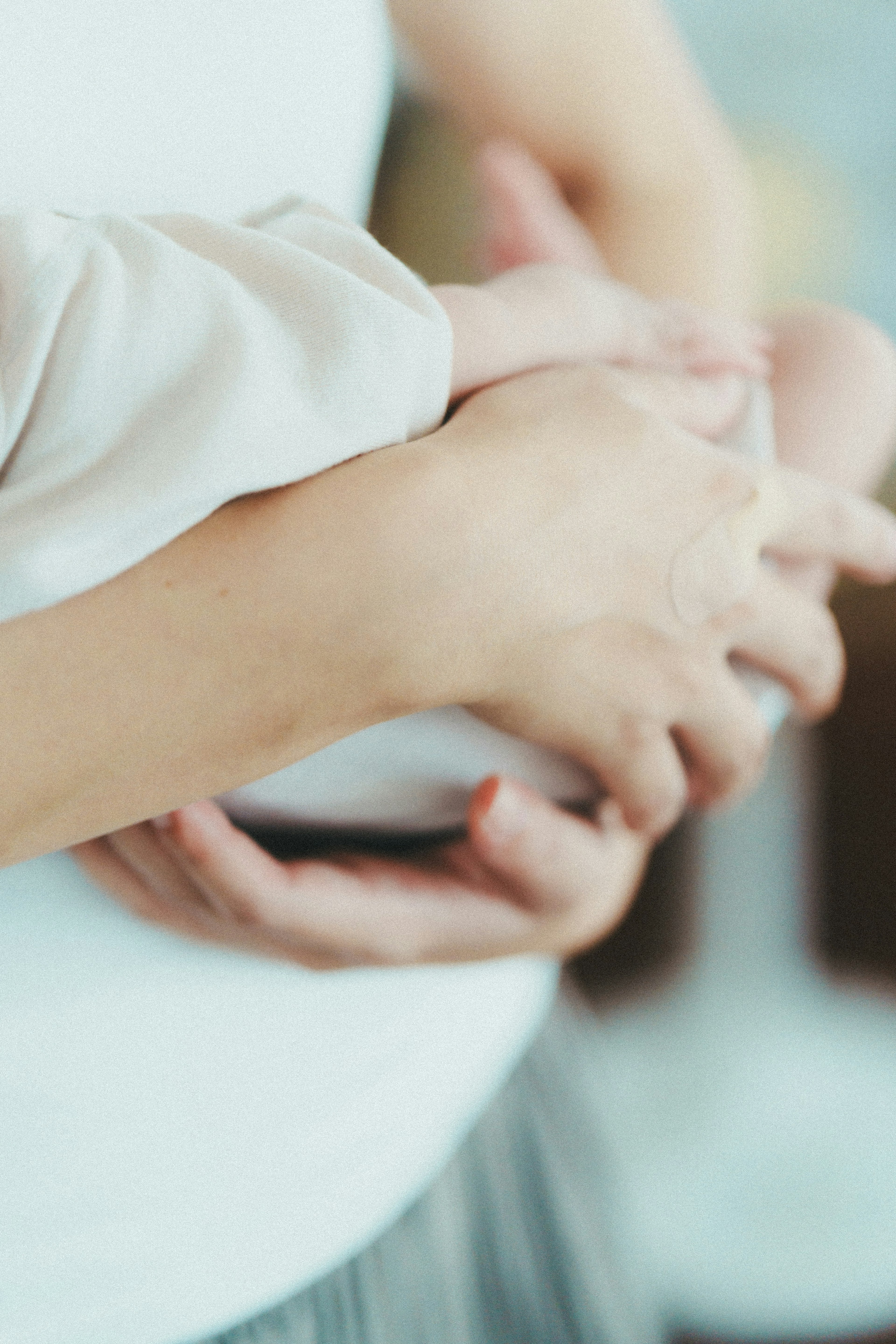 Close-up tangan yang memegang bayi dengan lembut nada warna lembut mengekspresikan cinta orang tua