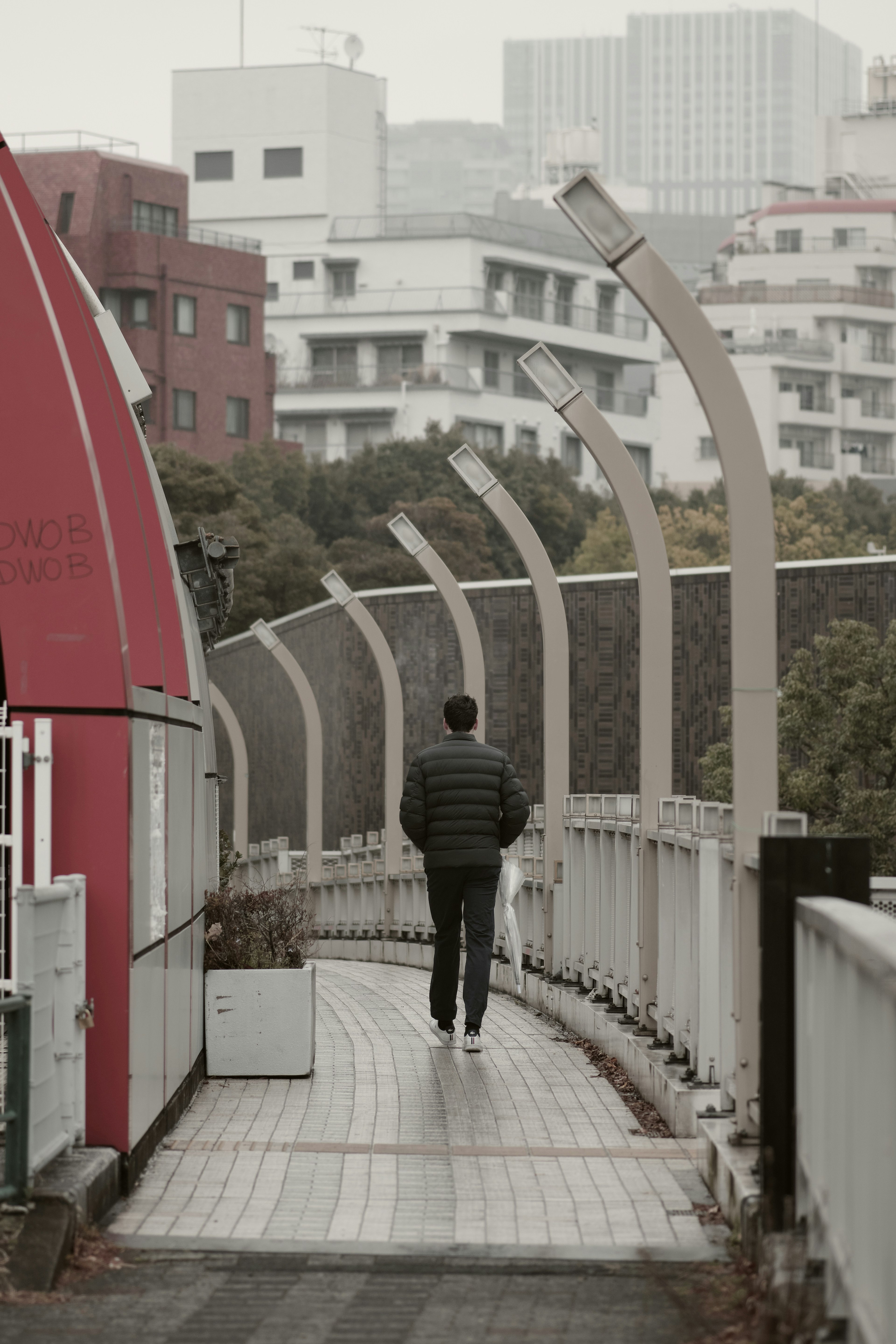 A man walking on a curved pathway in a quiet urban area