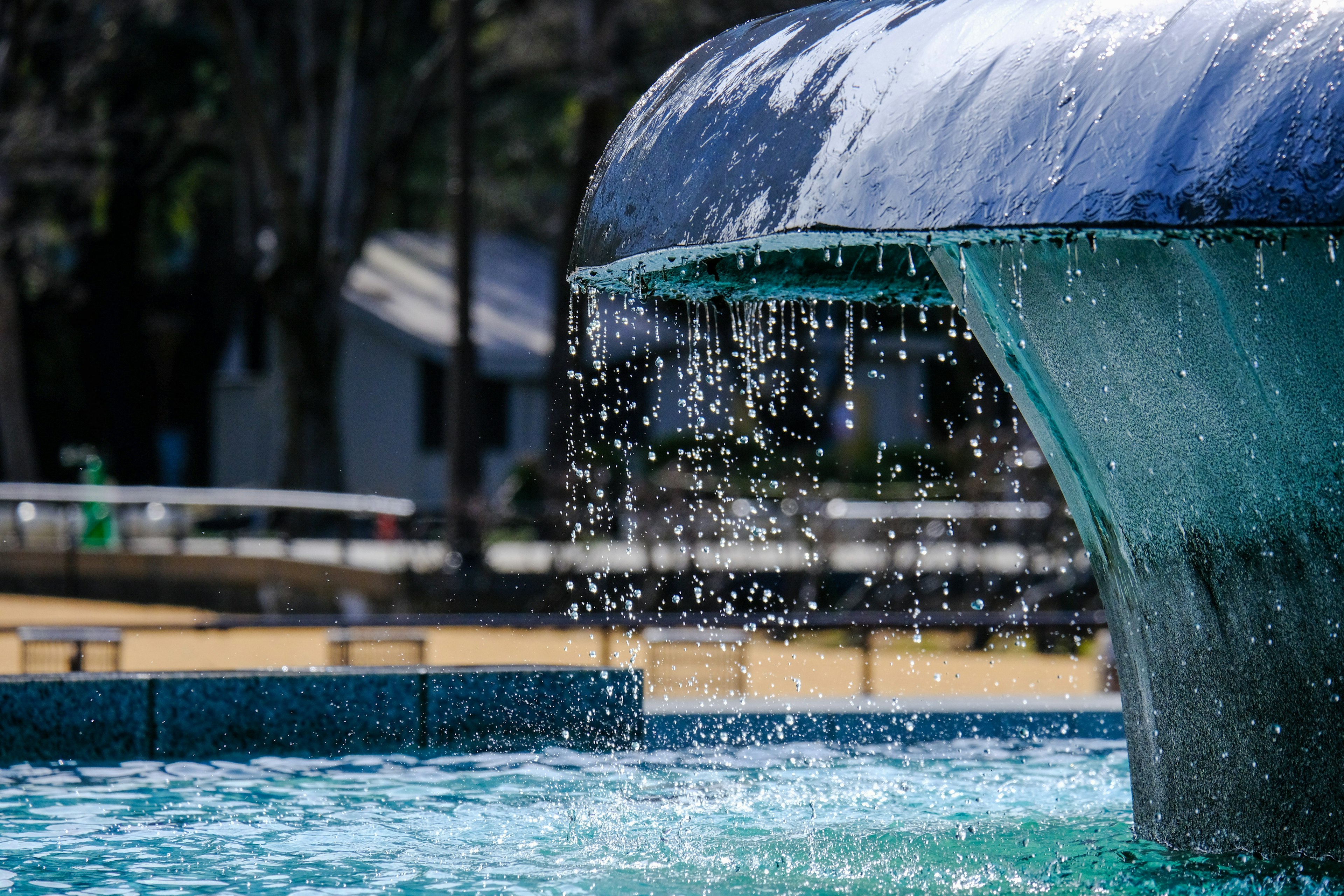 Close-up of a beautiful fountain with cascading water sparkling in sunlight over blue tiles