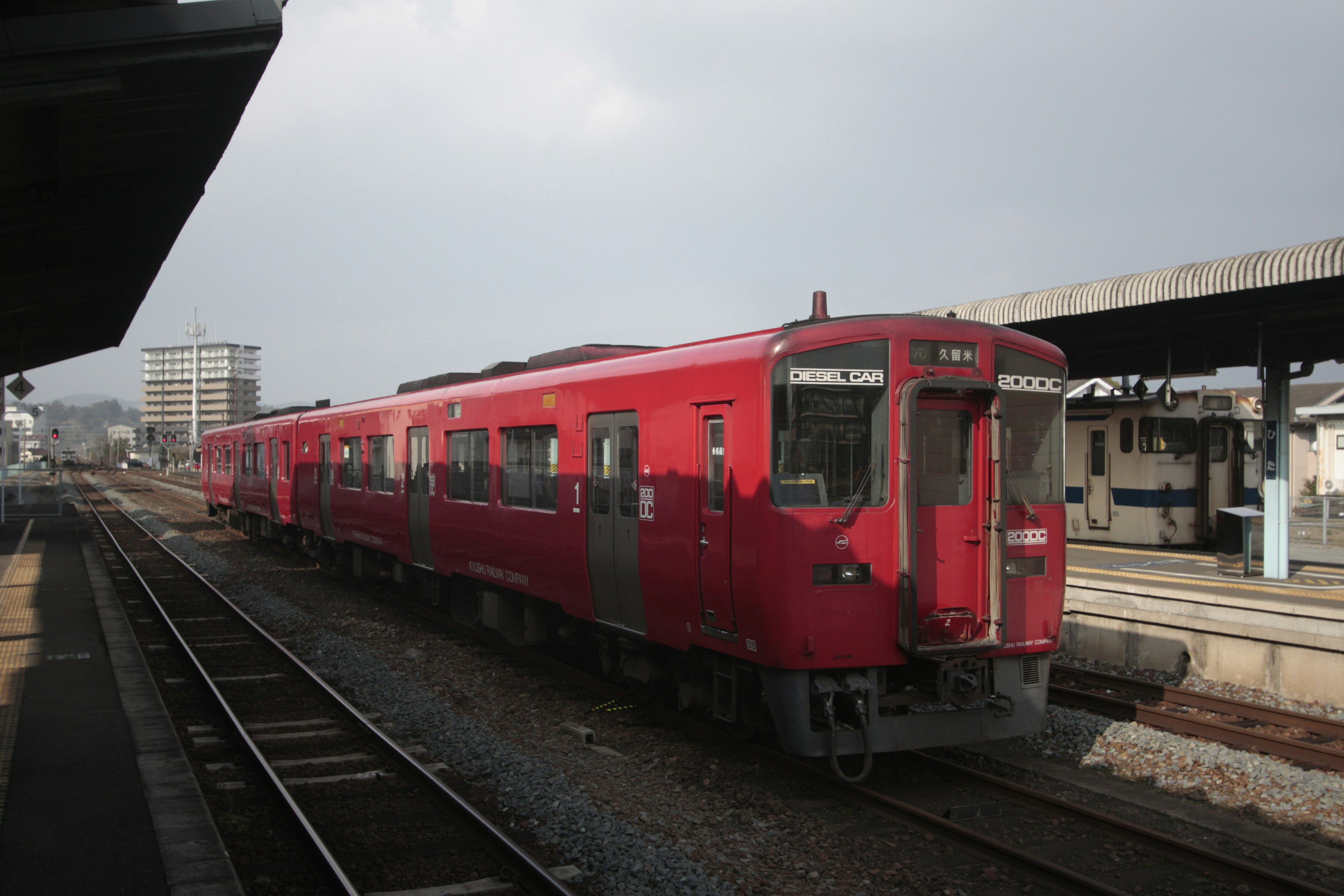 紅色列車停靠在車站，天空多雲