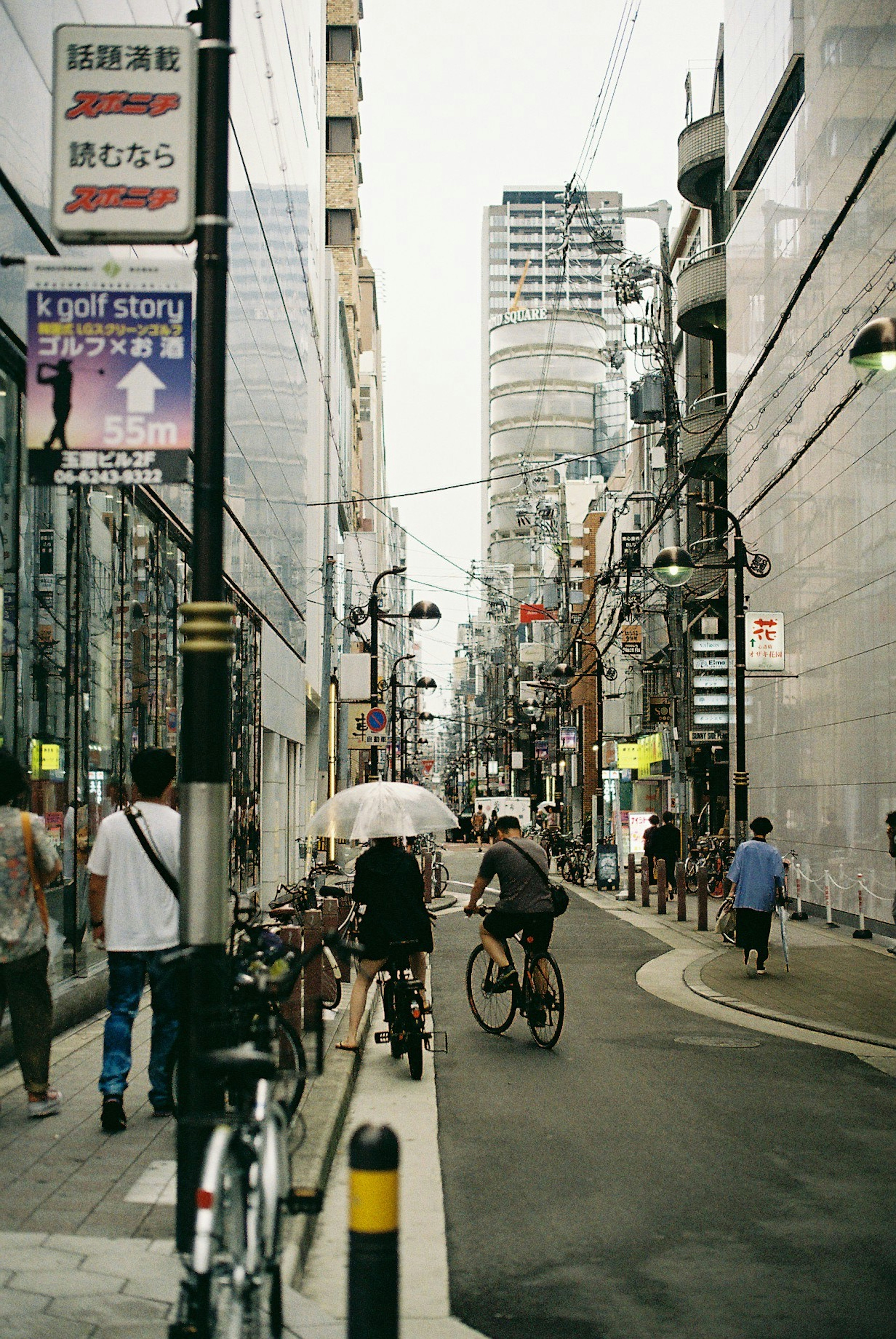 都市の通りに自転車と歩行者がいる風景