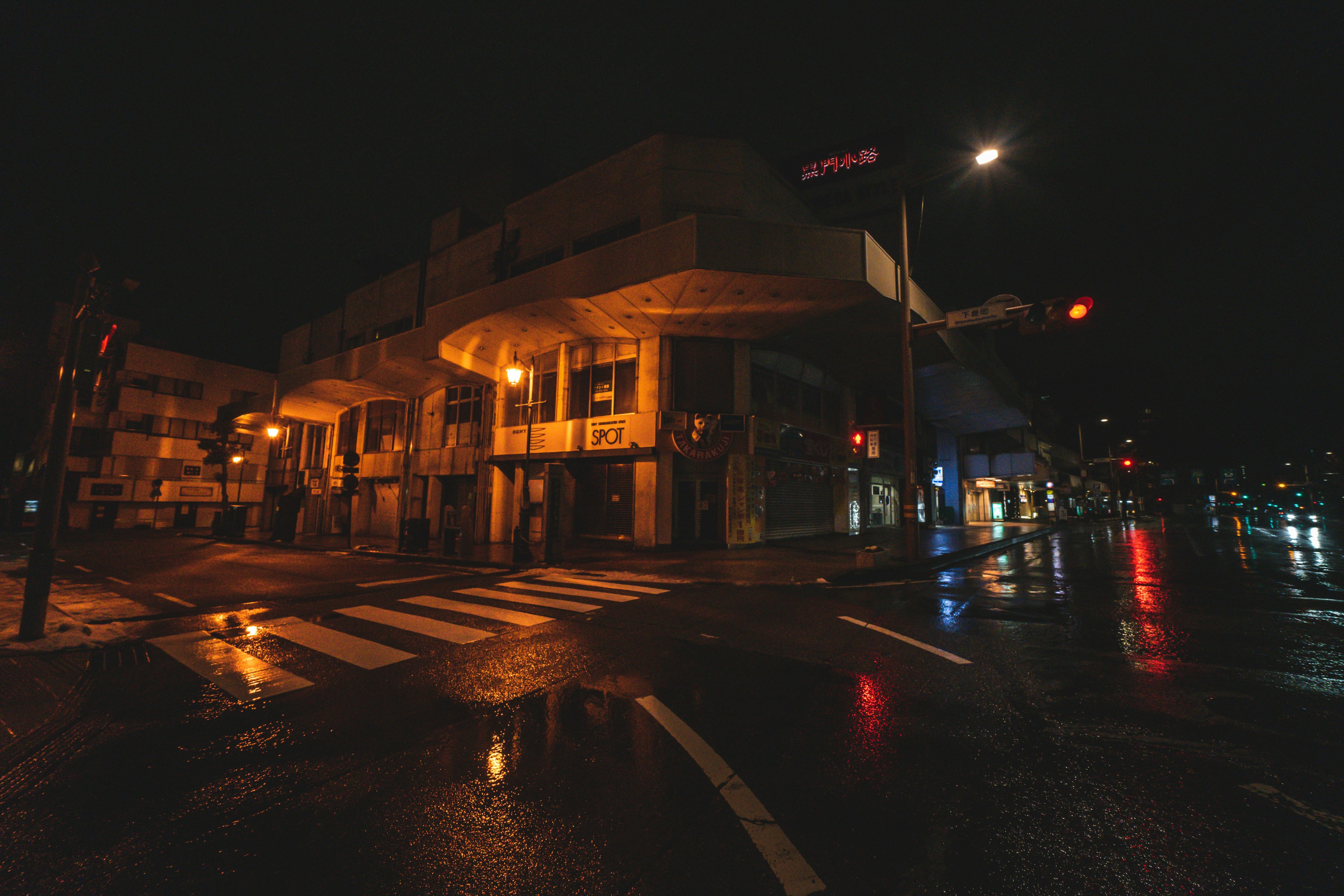 夜の街角にある濡れた道路と照明が反射する風景