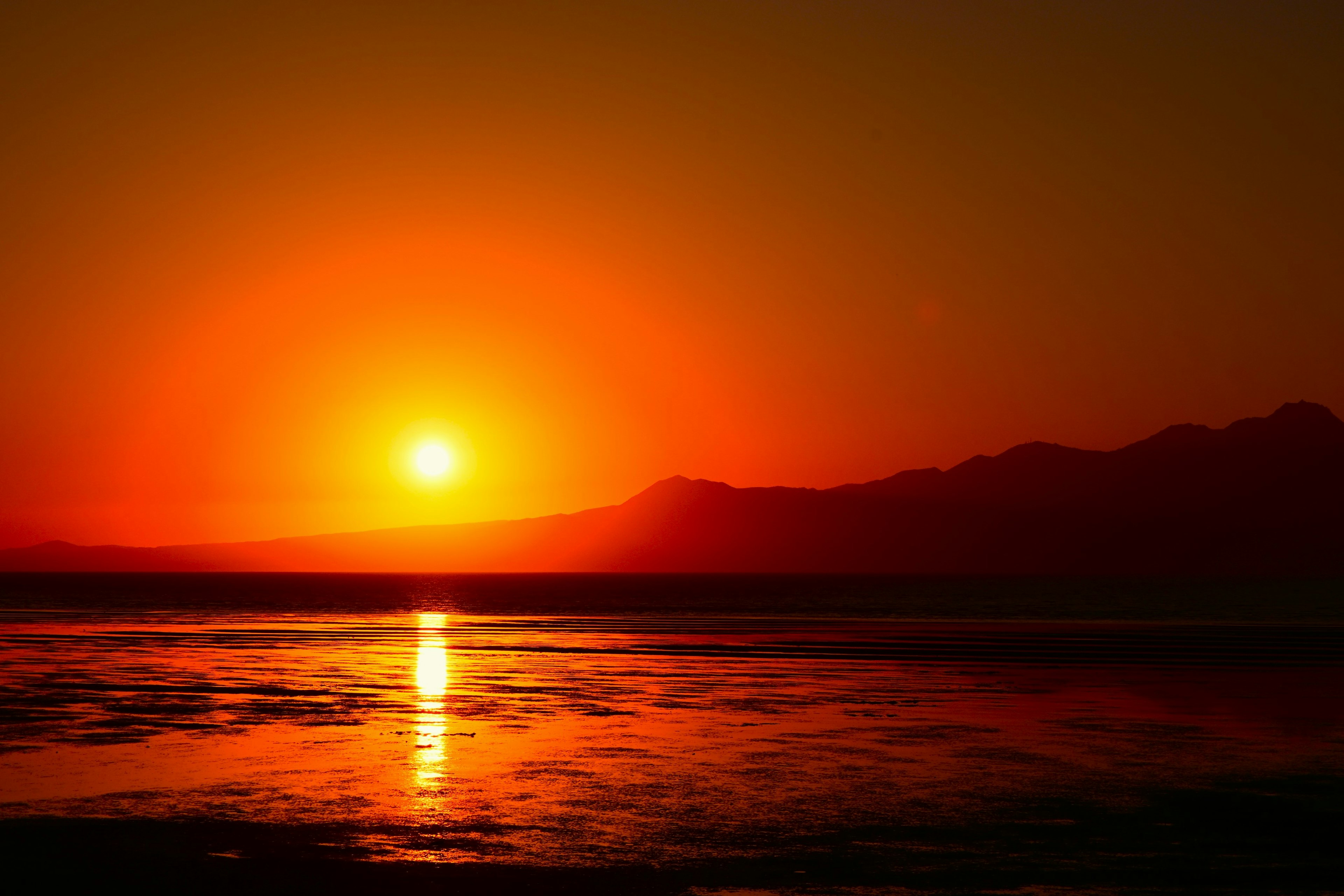 Schöner Sonnenuntergang über Bergen mit Reflexion im Wasser