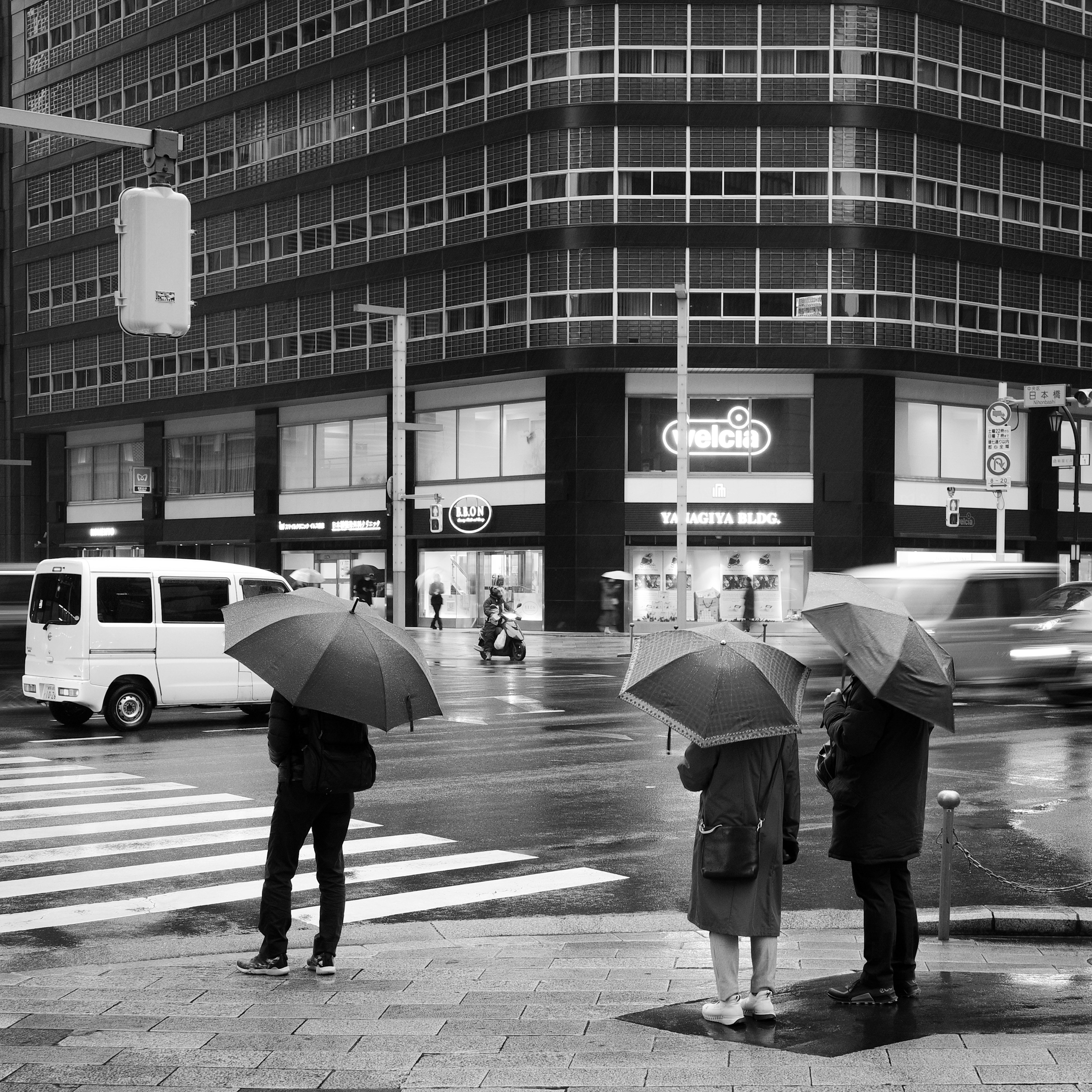 Personas con paraguas bajo la lluvia en un paisaje urbano