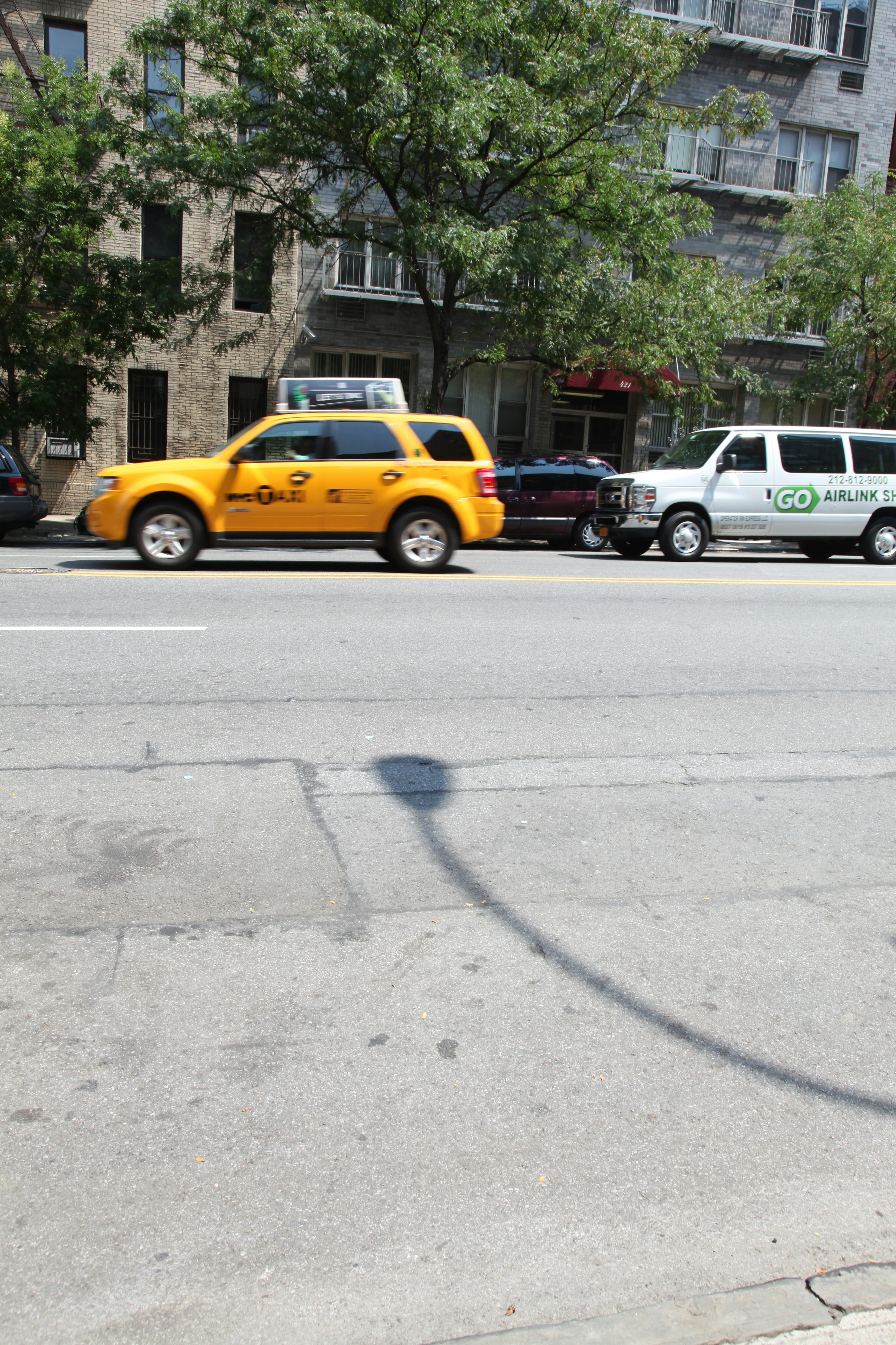 Taxi jaune et van blanc garés dans la rue d'une ville