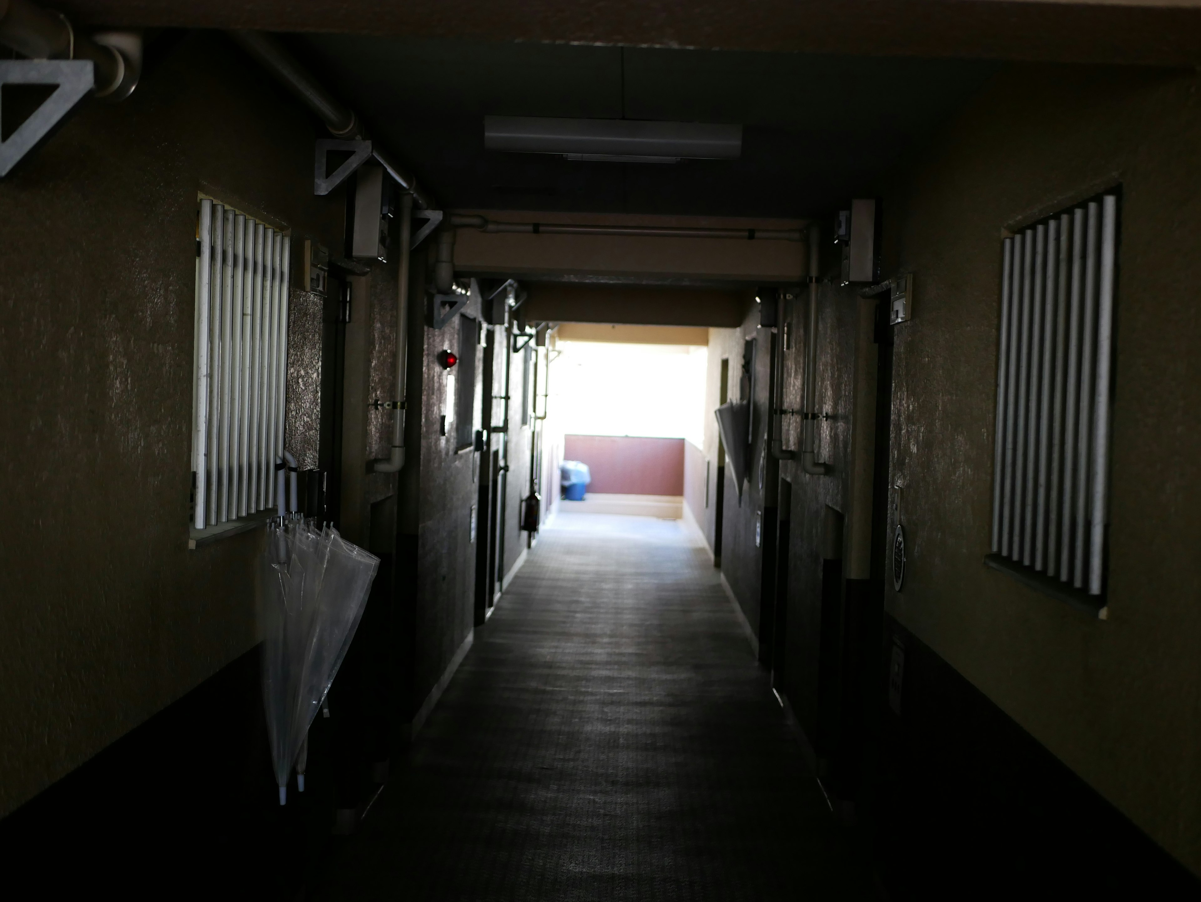 A dimly lit corridor with light at the end