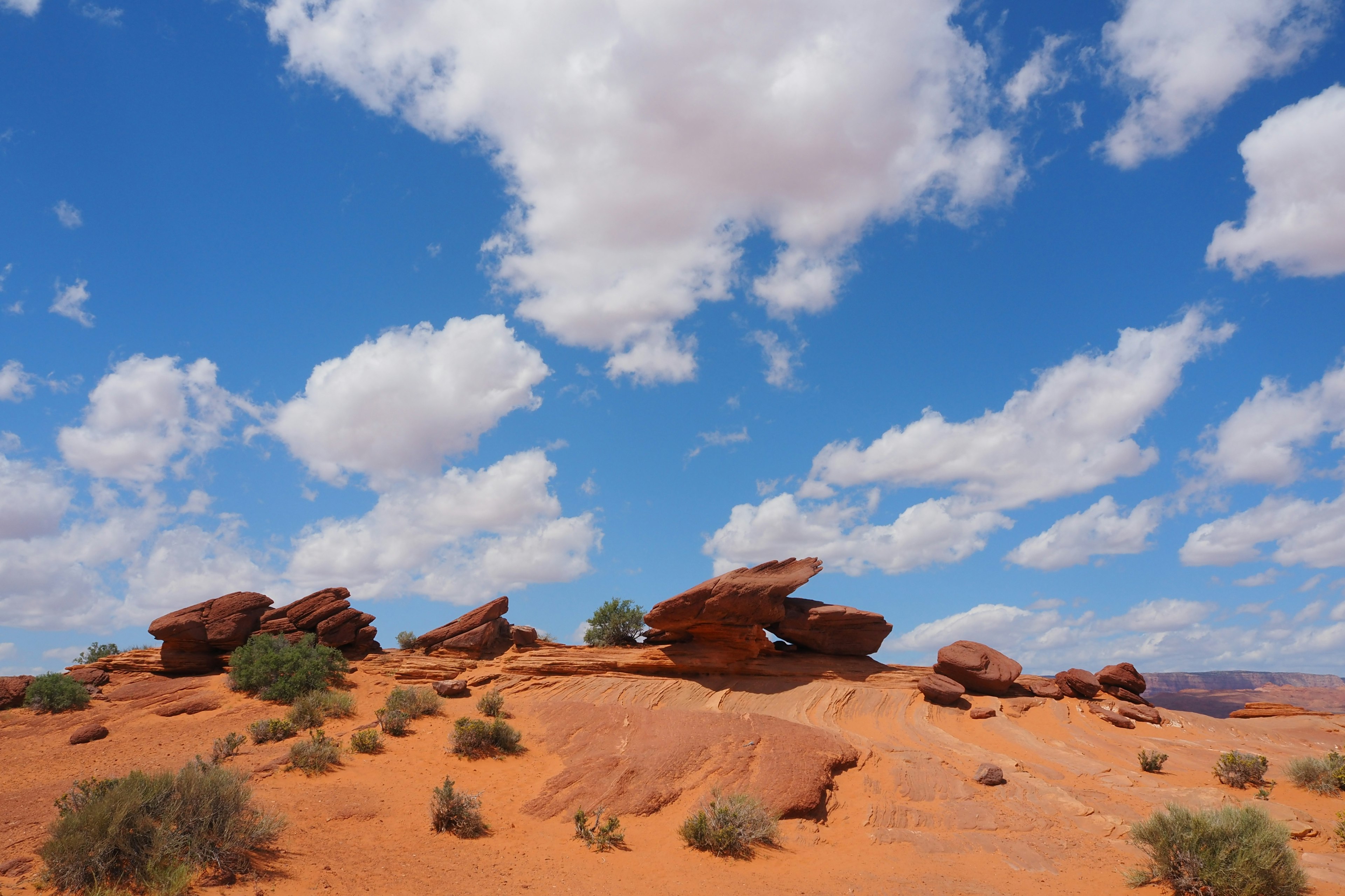 Landscape of red desert with scattered rocks and blue sky