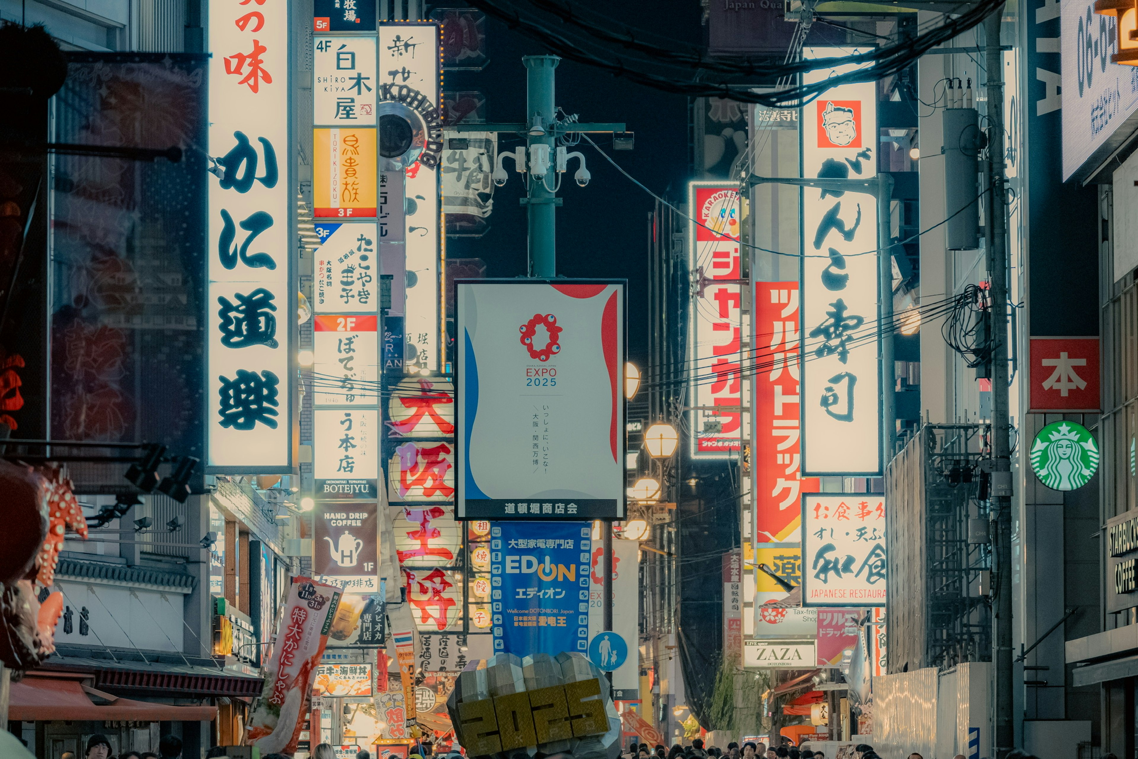 Colorful neon signs and people in a bustling street at night