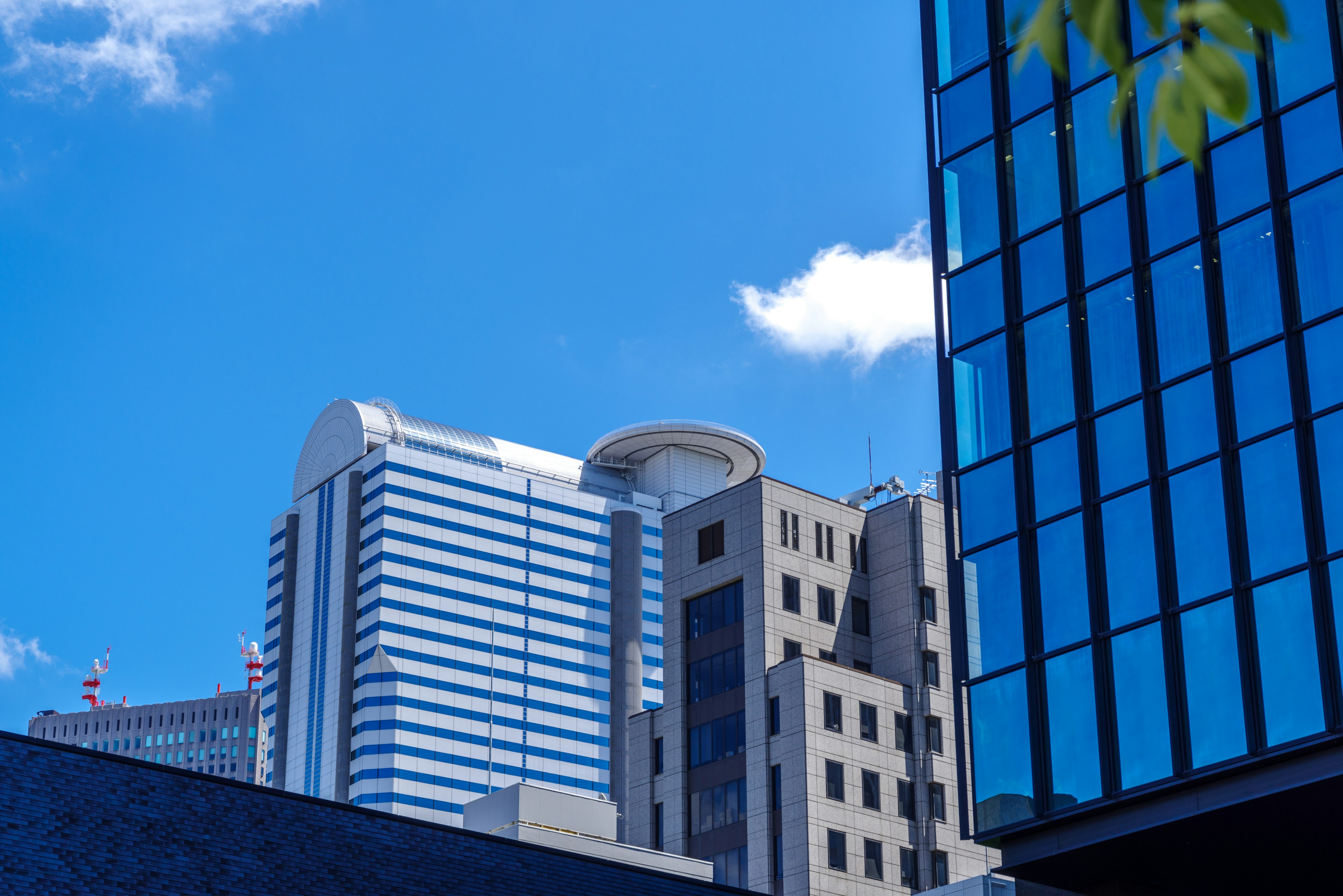 A cityscape featuring tall buildings under a blue sky