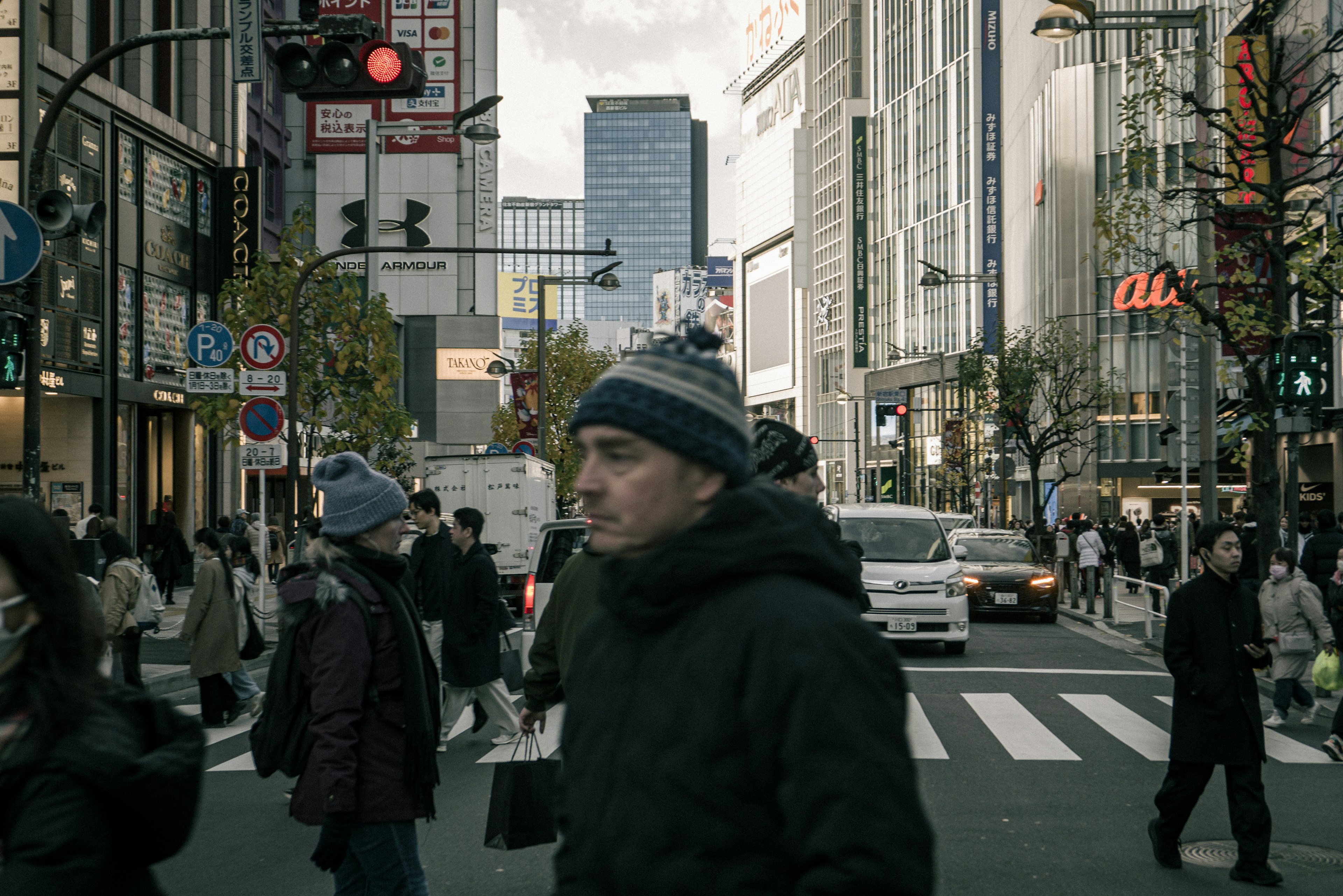 都市の交差点で人々が行き交う風景