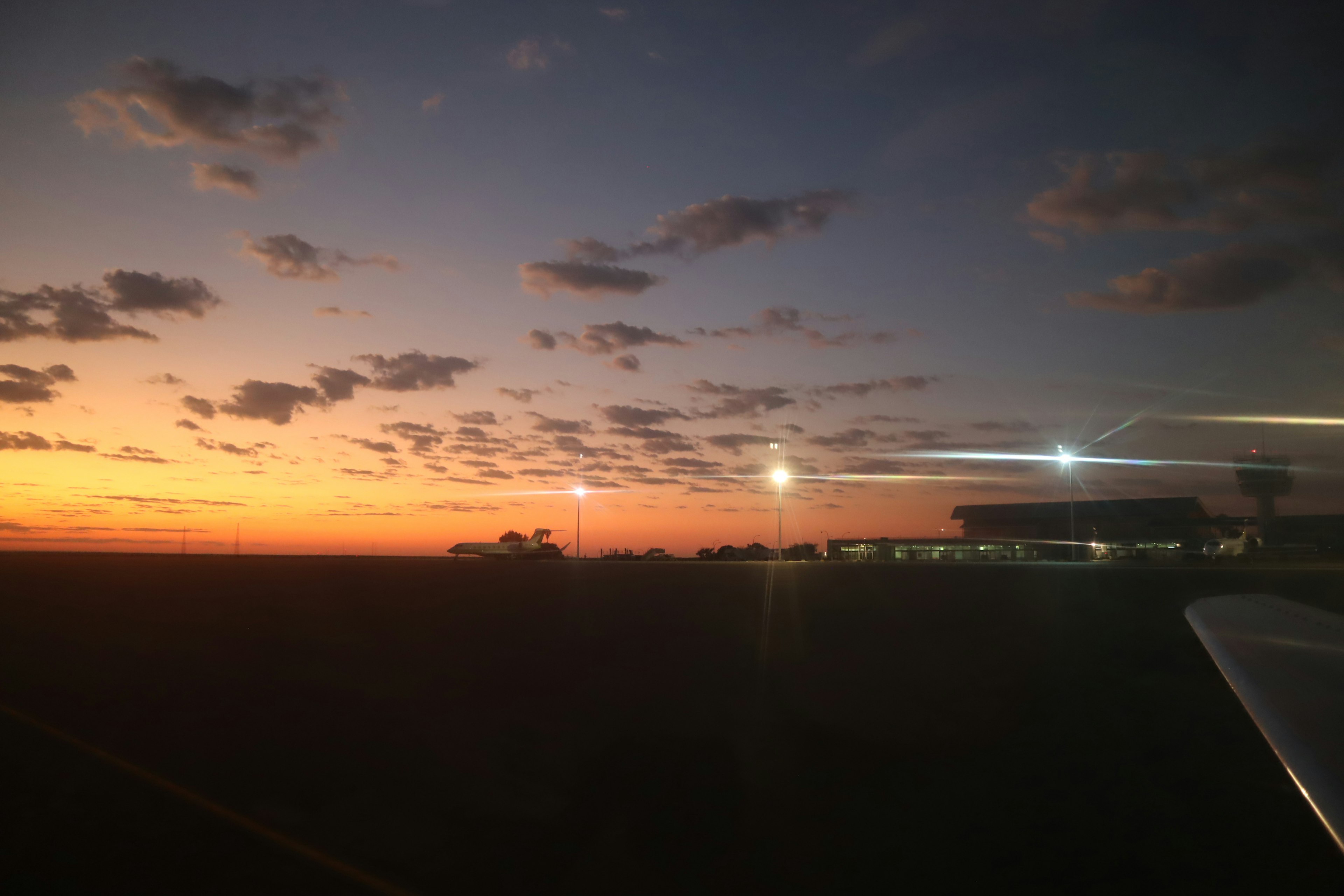 Langit senja dengan siluet bandara dan awan