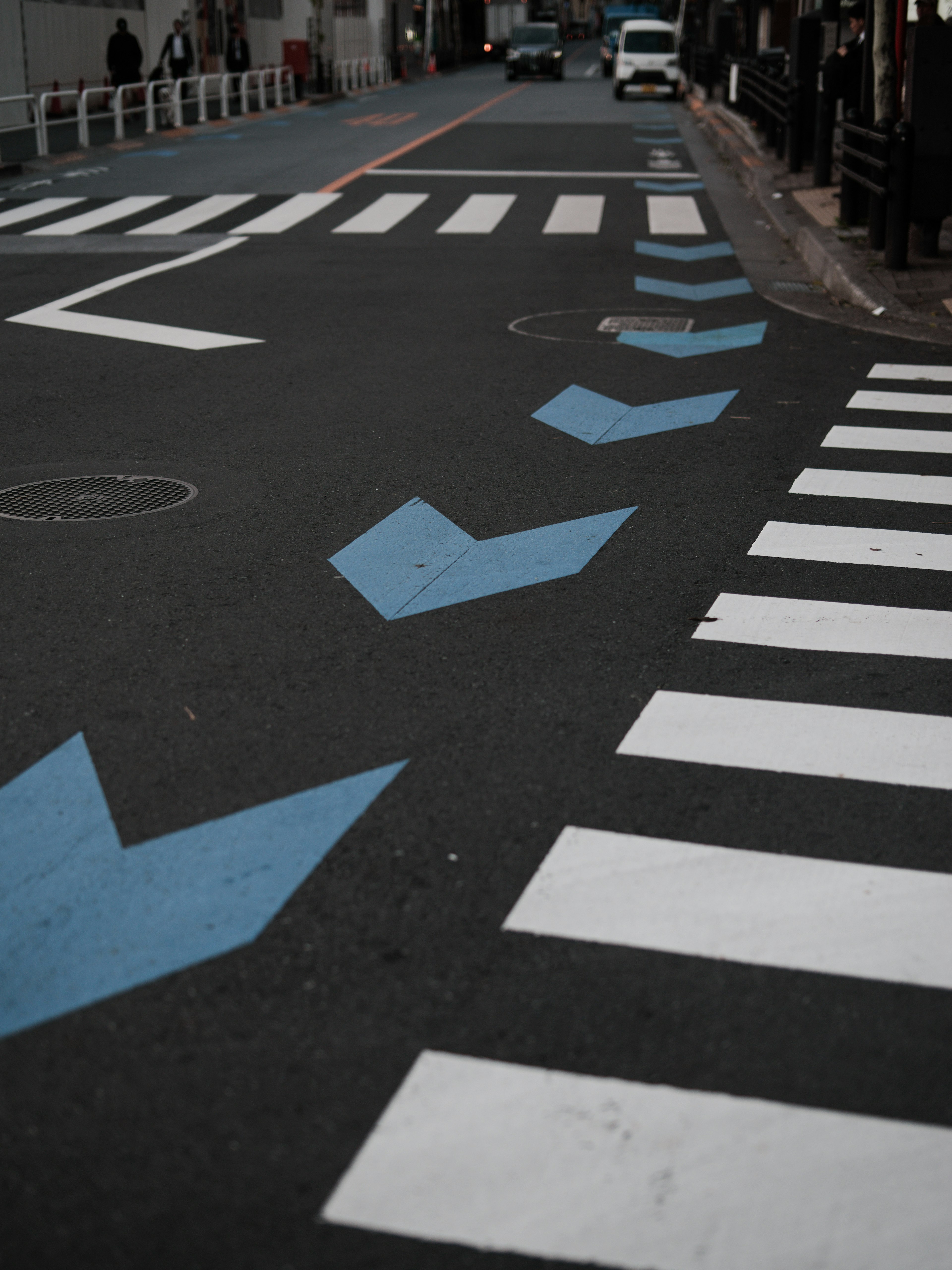 Intersection avec des flèches bleues et des passages piétons blancs