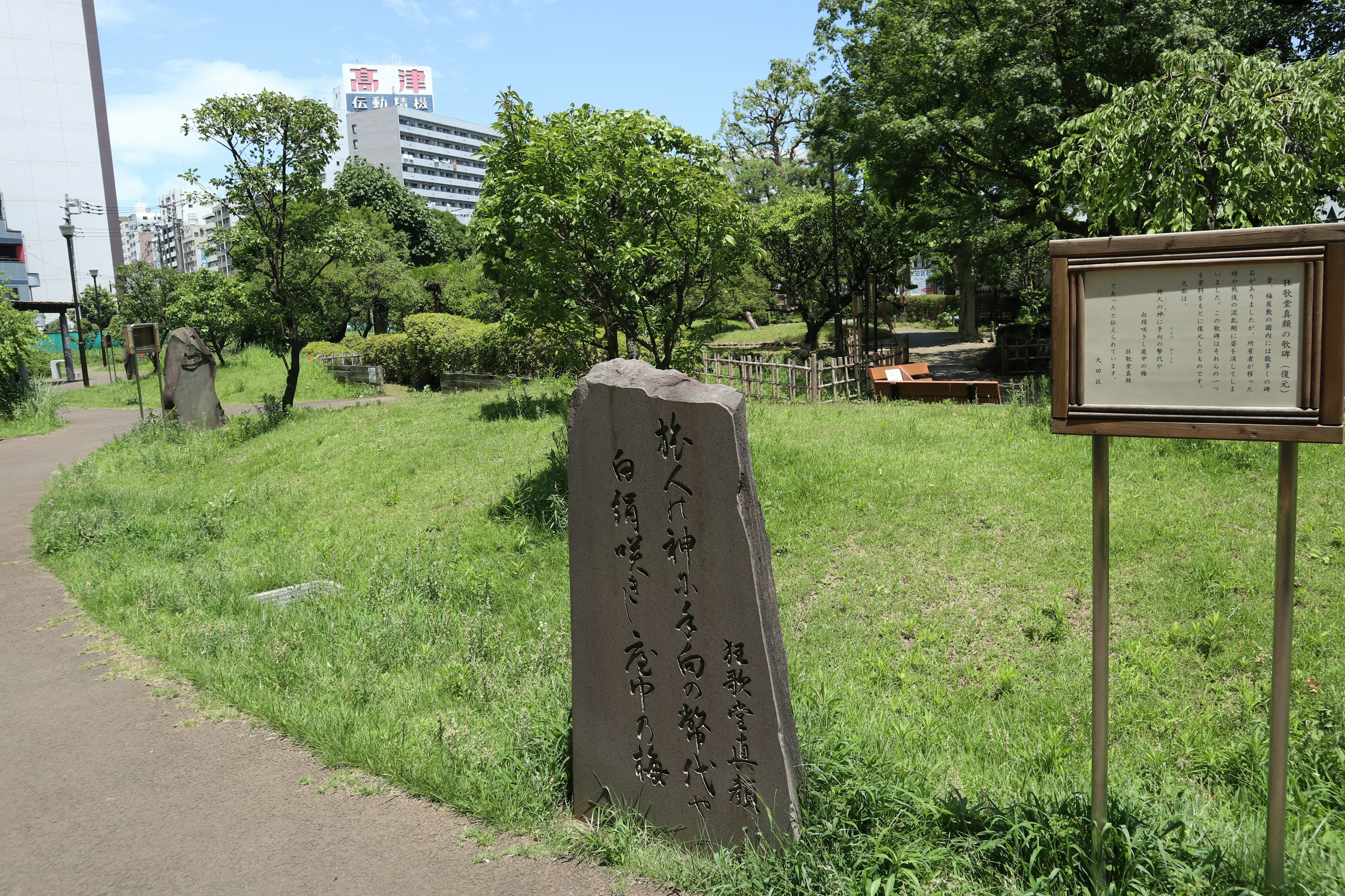 Paysage avec un monument en pierre et un panneau d'information dans un parc