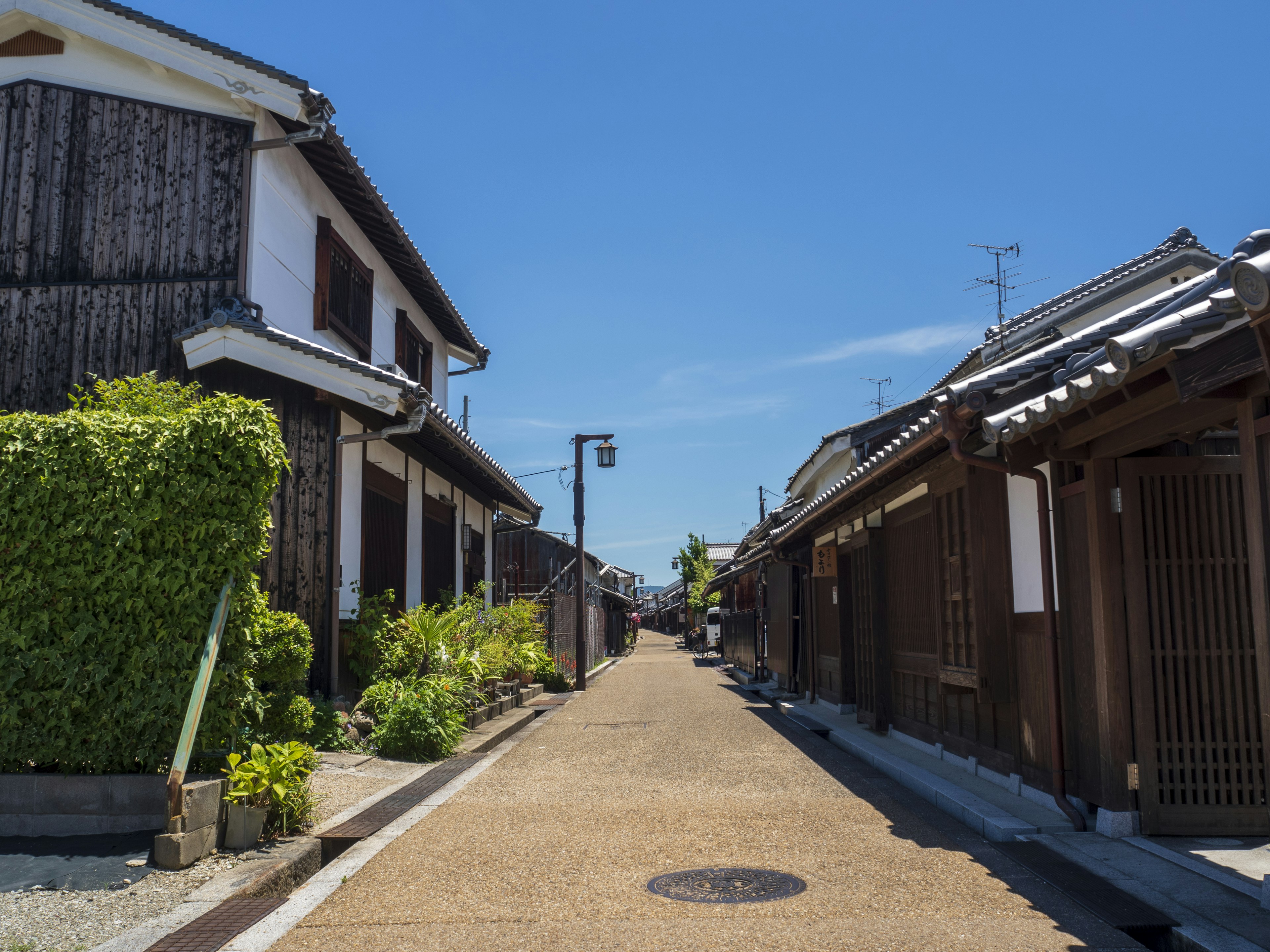 Rue japonaise tranquille avec des maisons traditionnelles et un ciel bleu clair