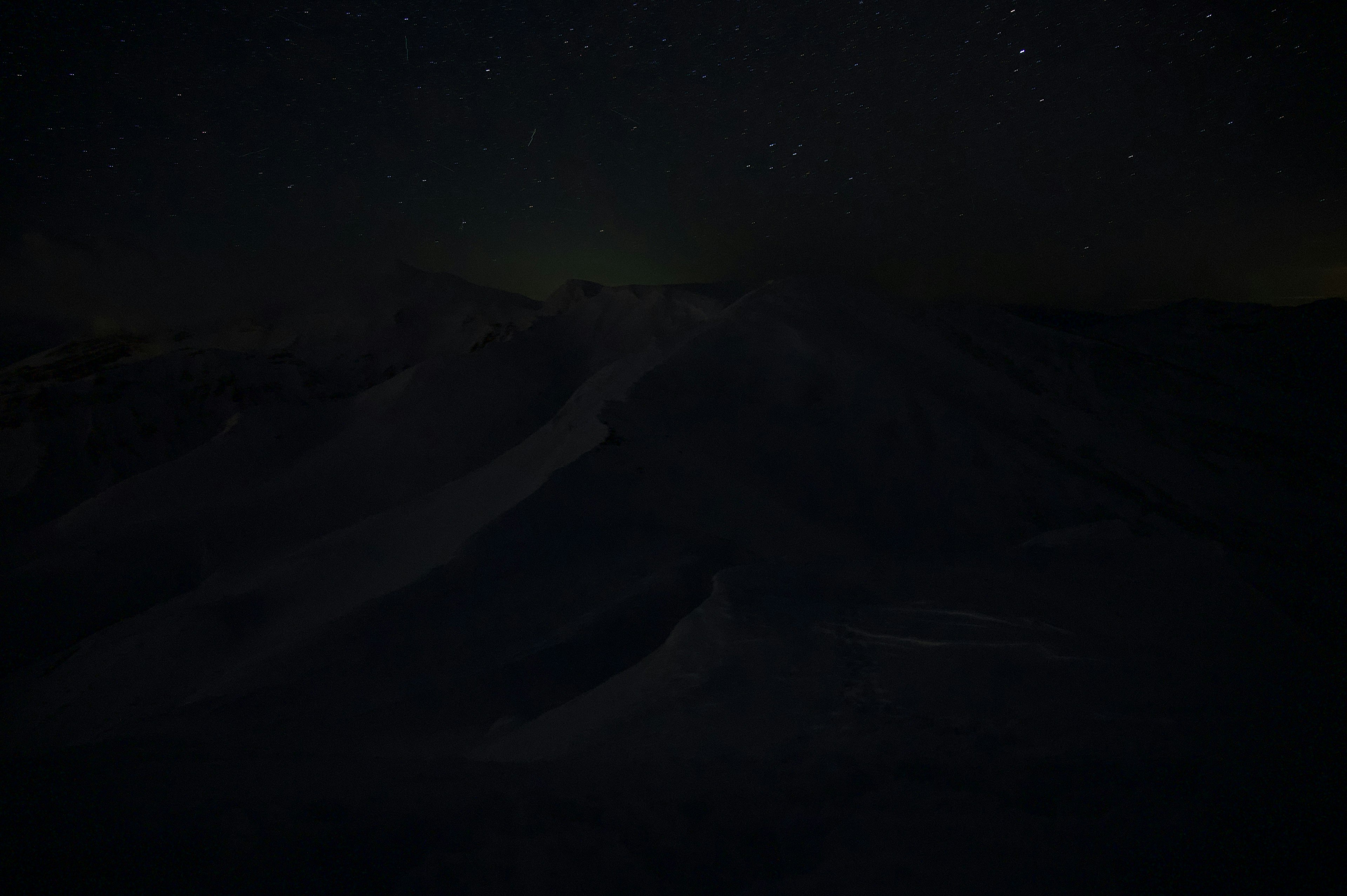 暗い山の風景に星が輝く夜空