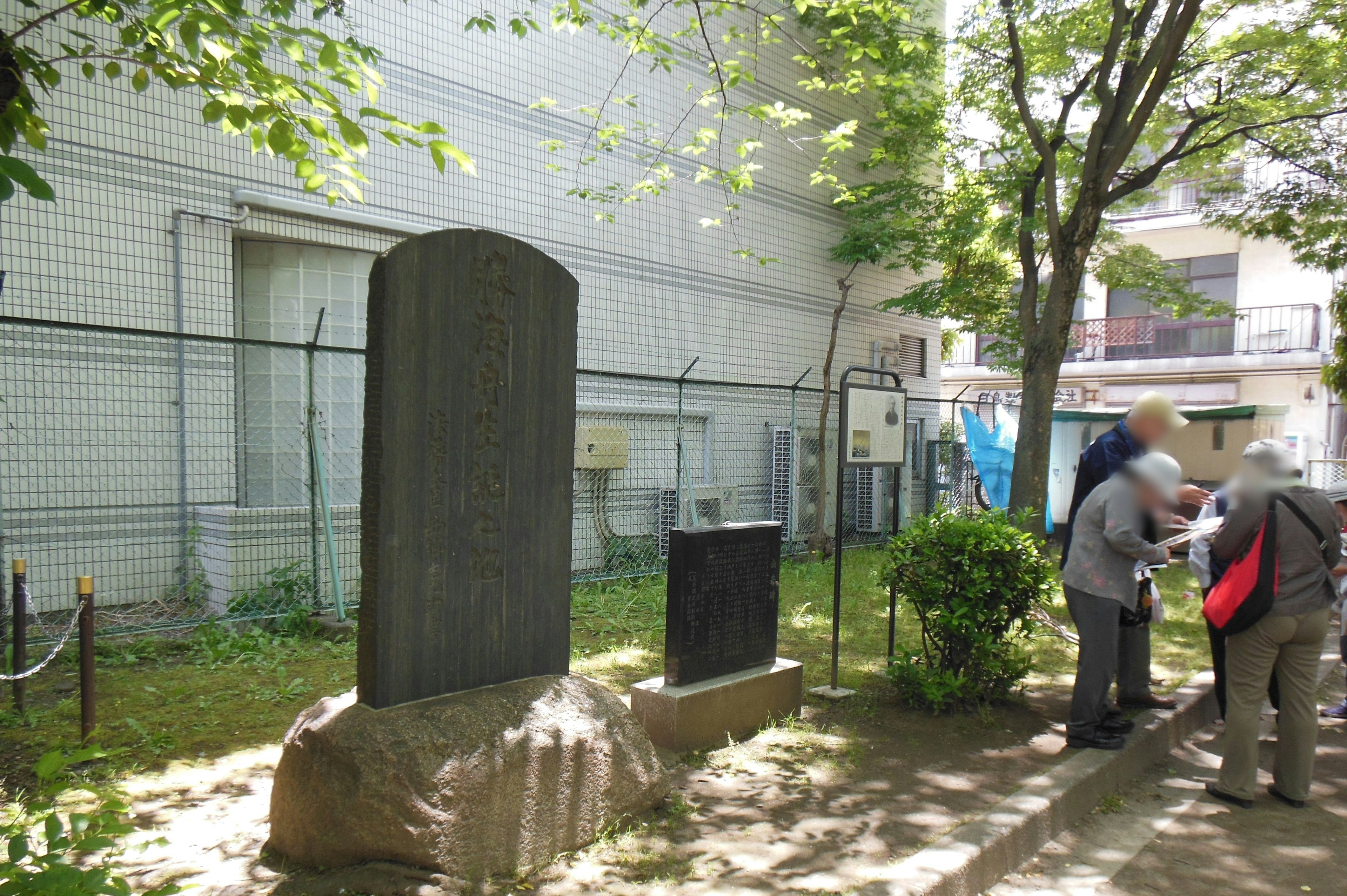 Dos monumentos de piedra en un parque con visitantes