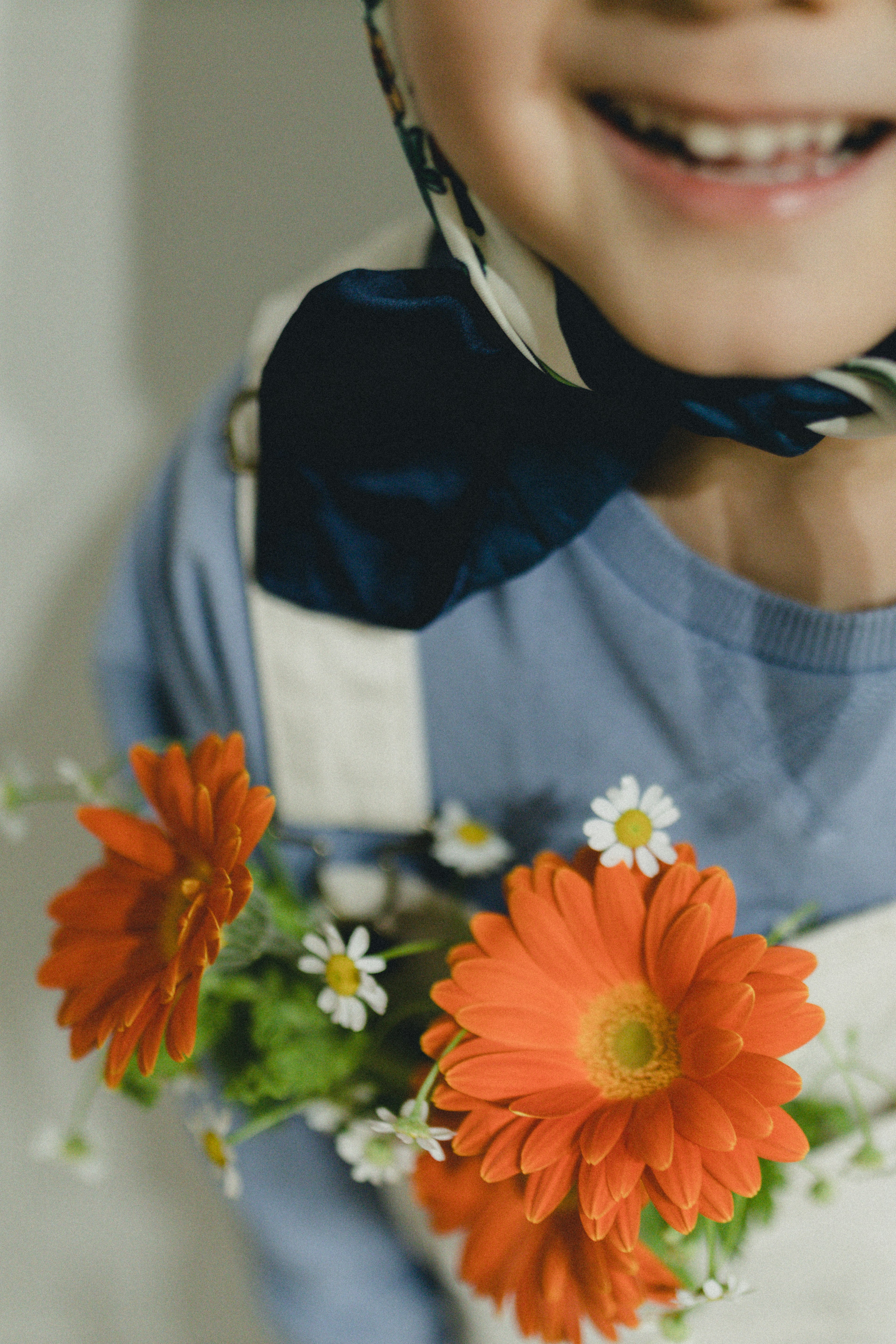 Bambino sorridente con fiori arancioni