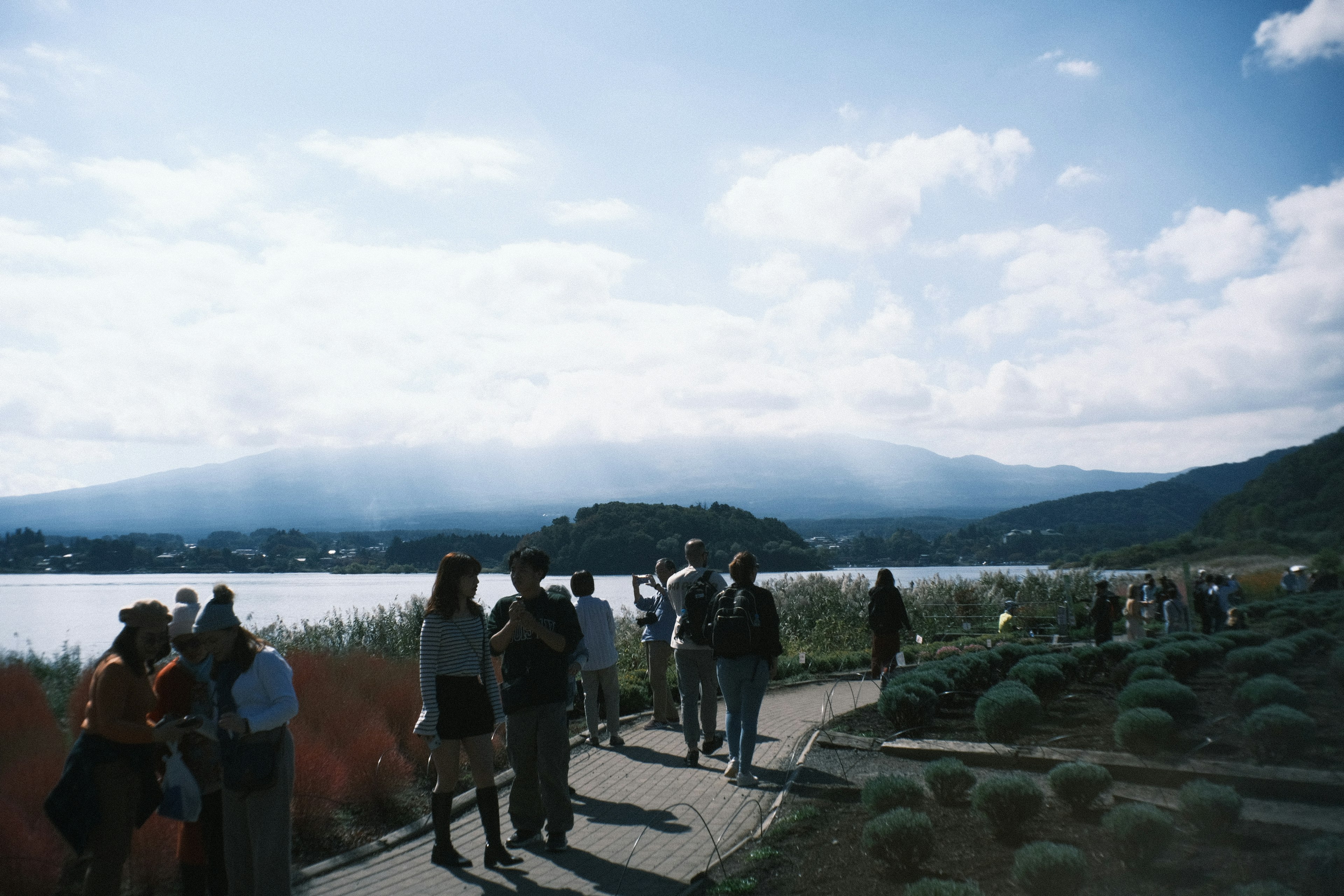 Turistas caminando cerca de un lago con paisaje montañoso