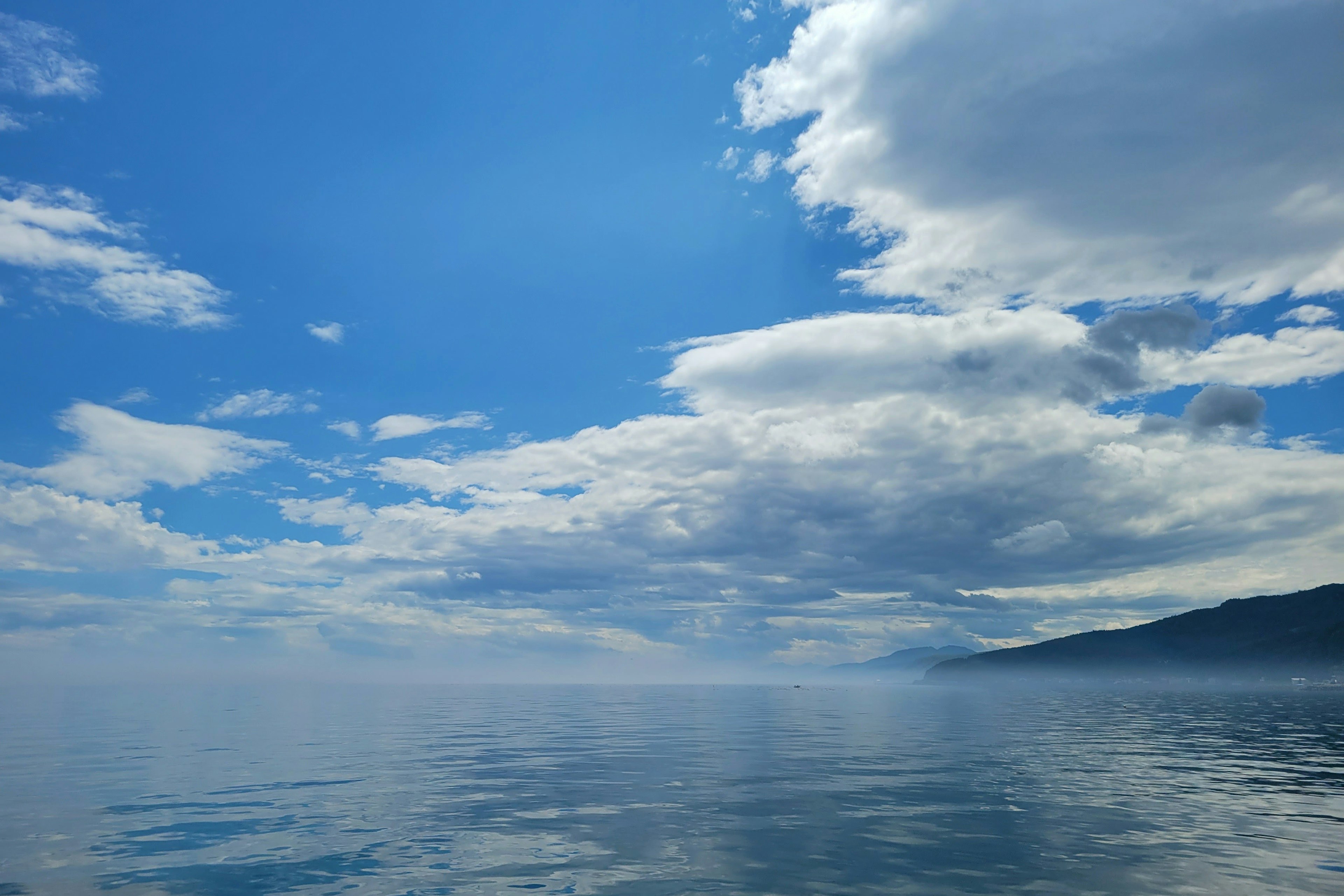 Paisaje marino tranquilo con cielo azul y nubes blancas