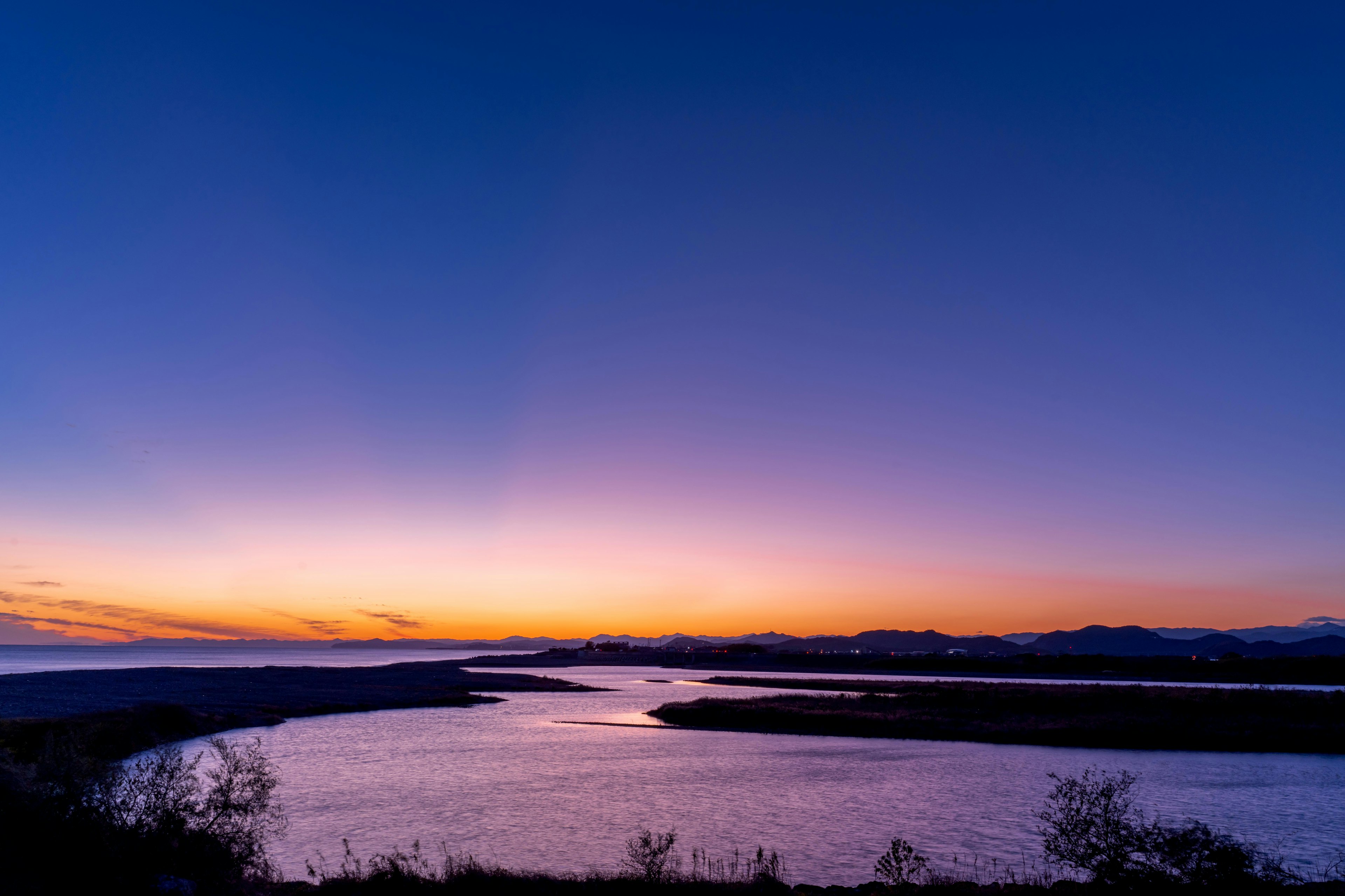 美しい夕焼けの川の風景と青紫の空