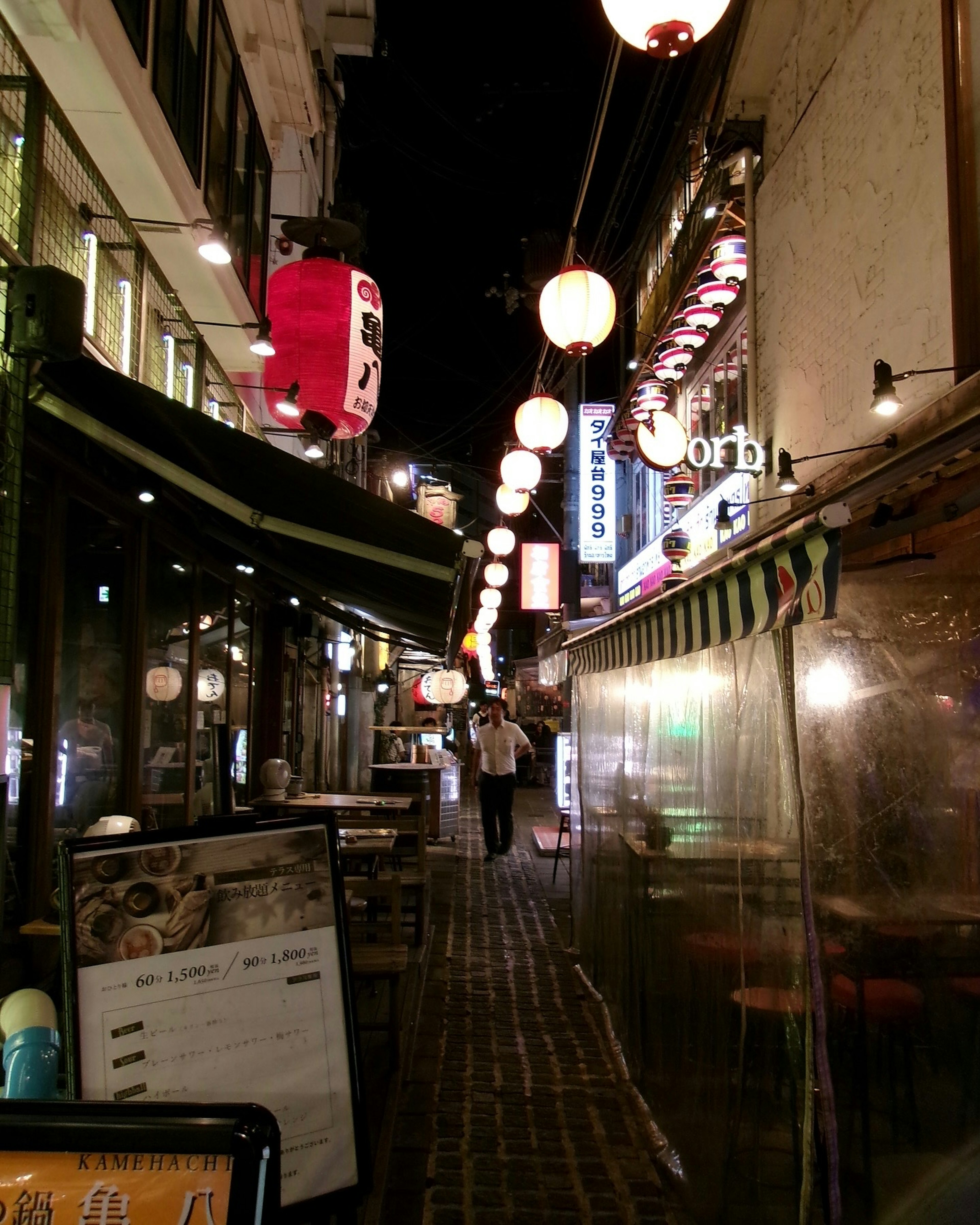 Straßenszene bei Nacht mit Laternen und Restaurantfassaden