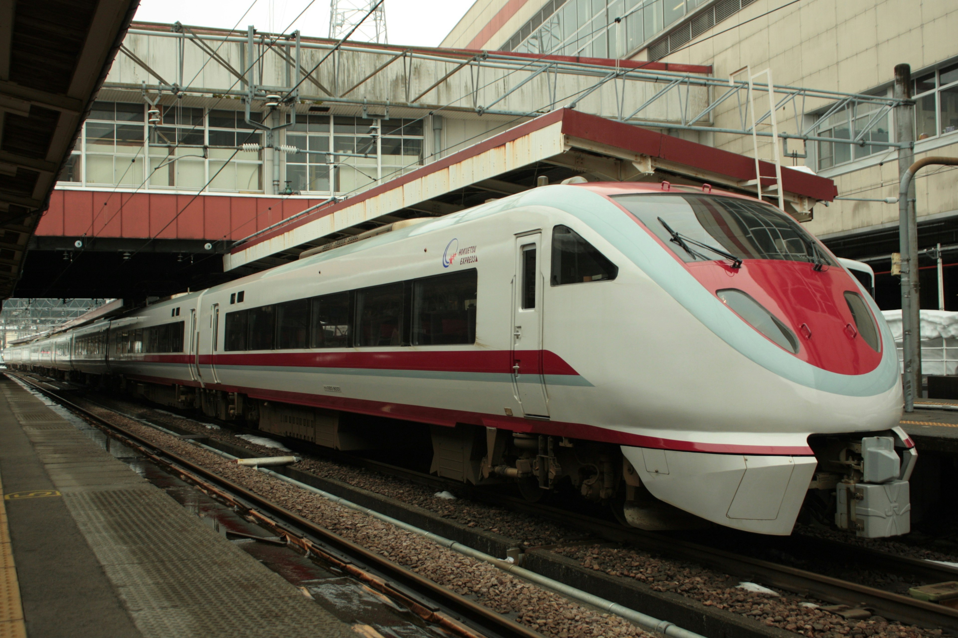 Shinkansen train with red and white design parked at the station