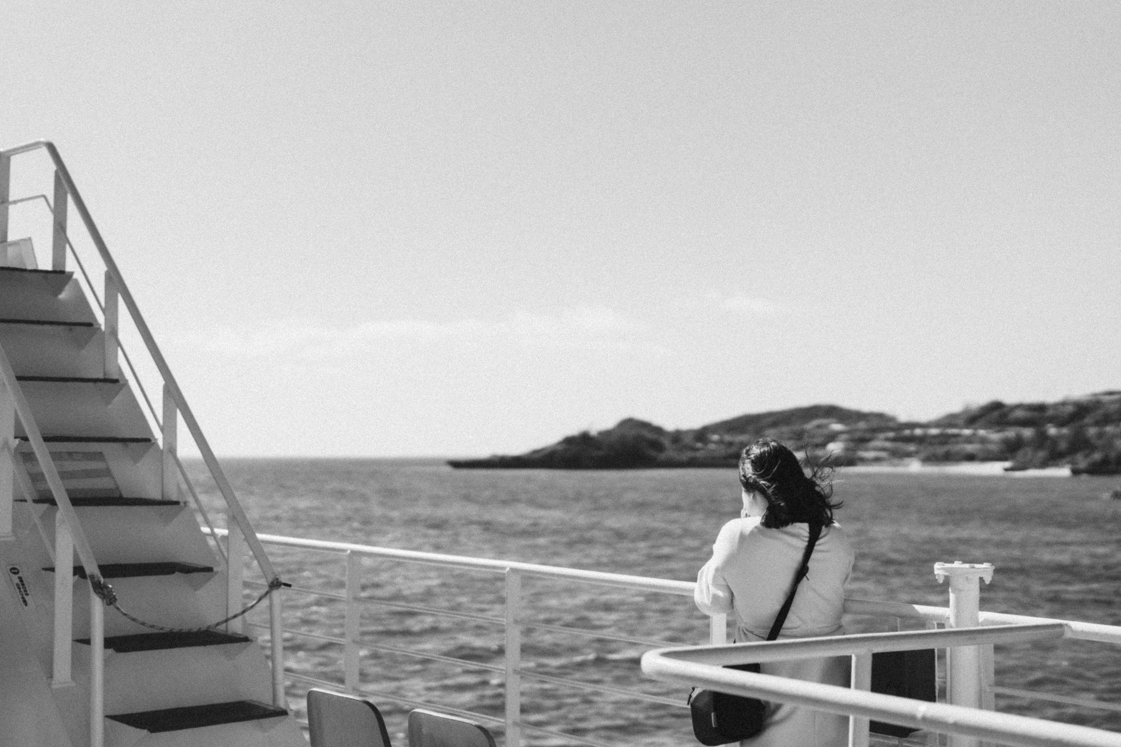 Eine Frau, die von einem Boot mit Treppen auf das Meer schaut