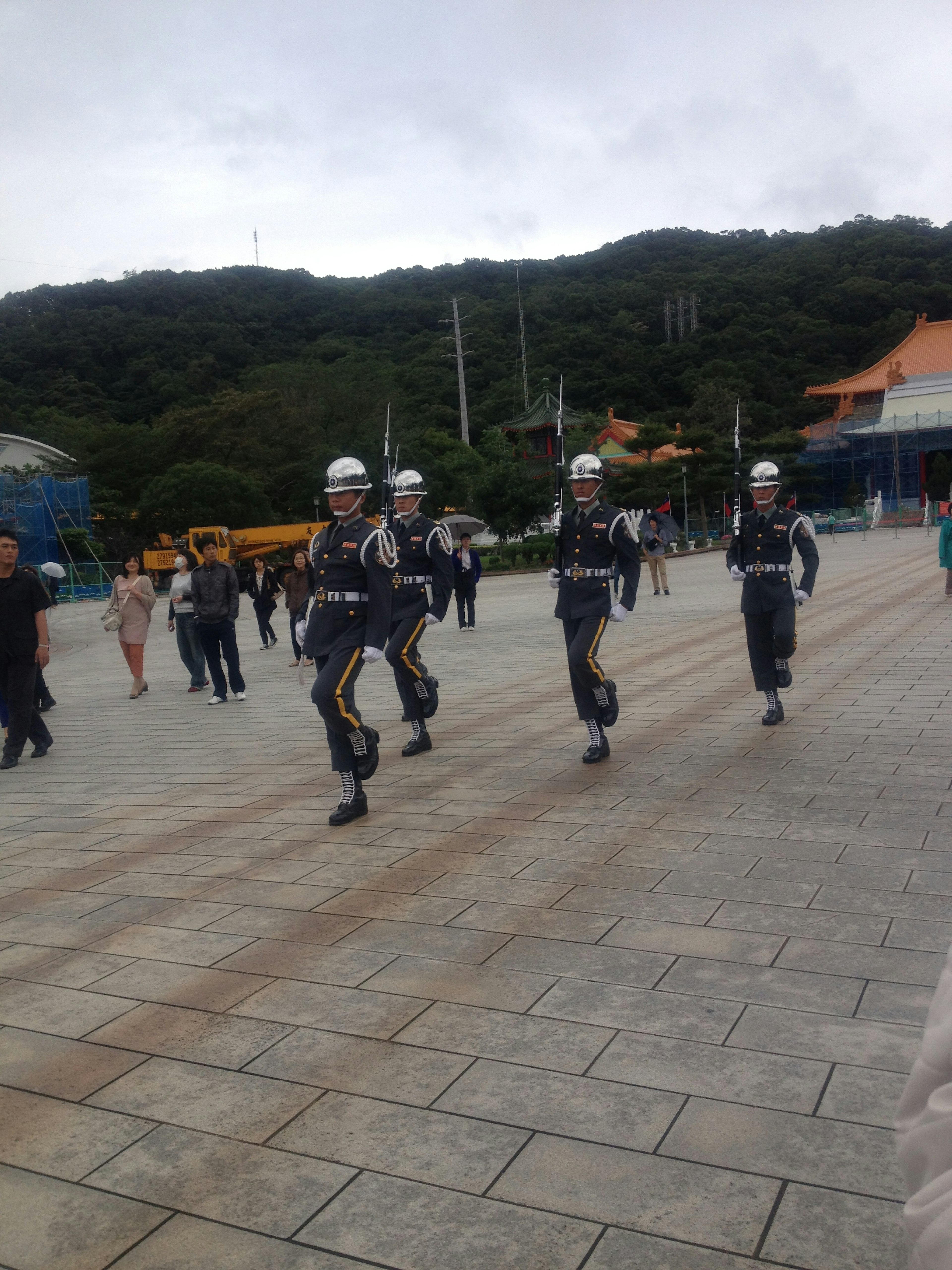 Police officers marching in formation with tourists and mountains in the background