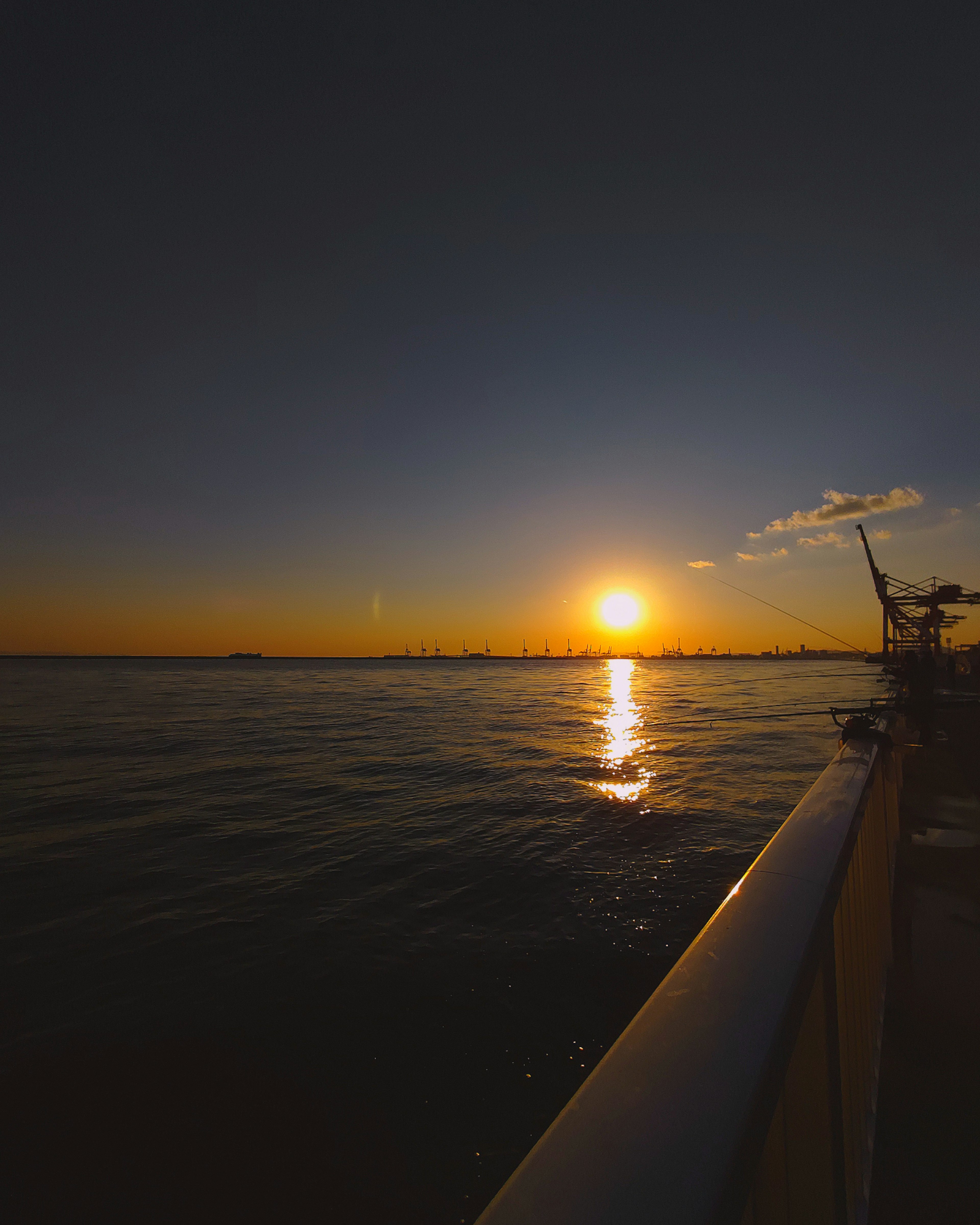 Bellissimo tramonto sull'oceano con una ringhiera in primo piano