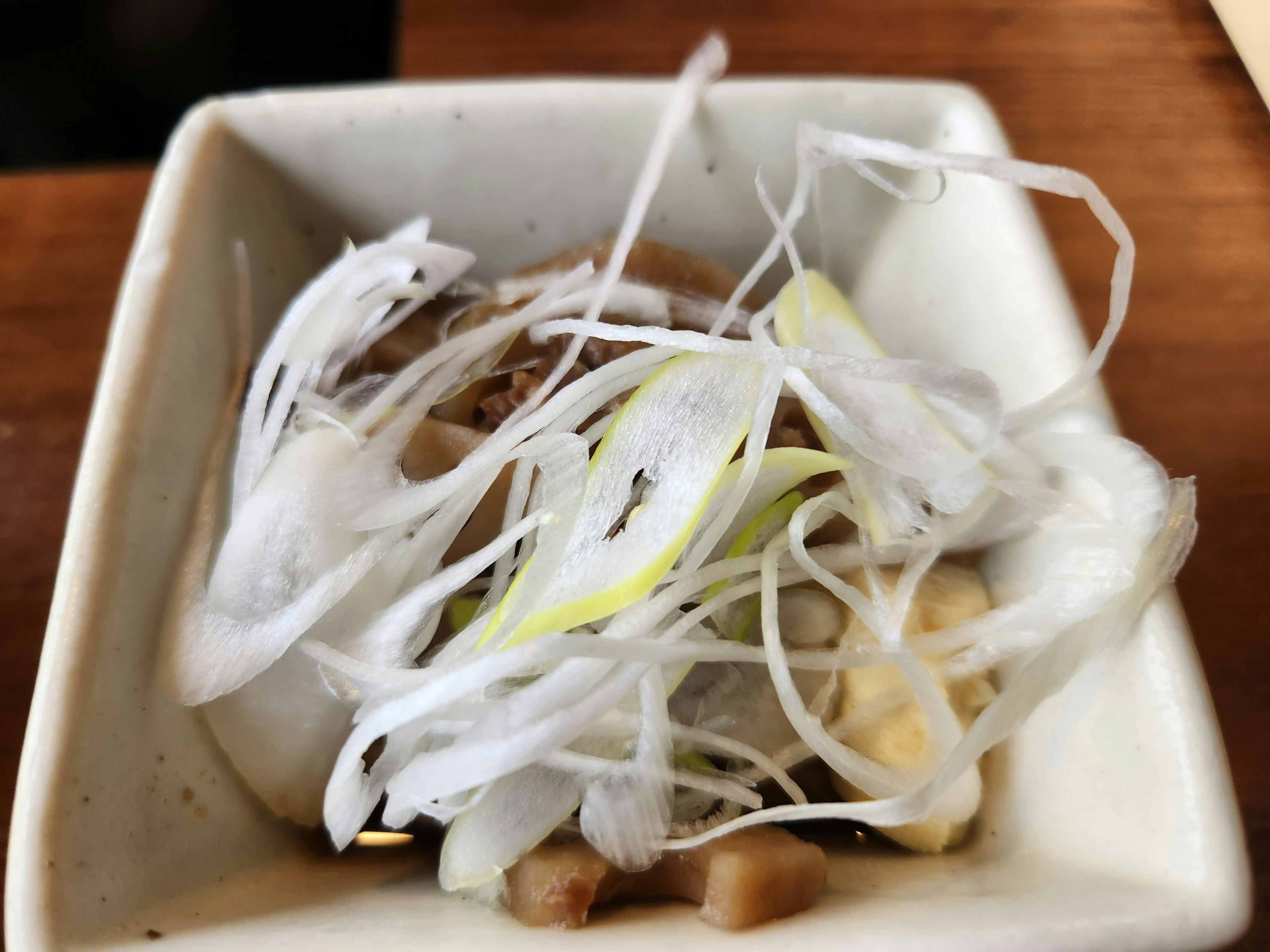 Pequeño plato con cebollas verdes finamente rebanadas y aderezos