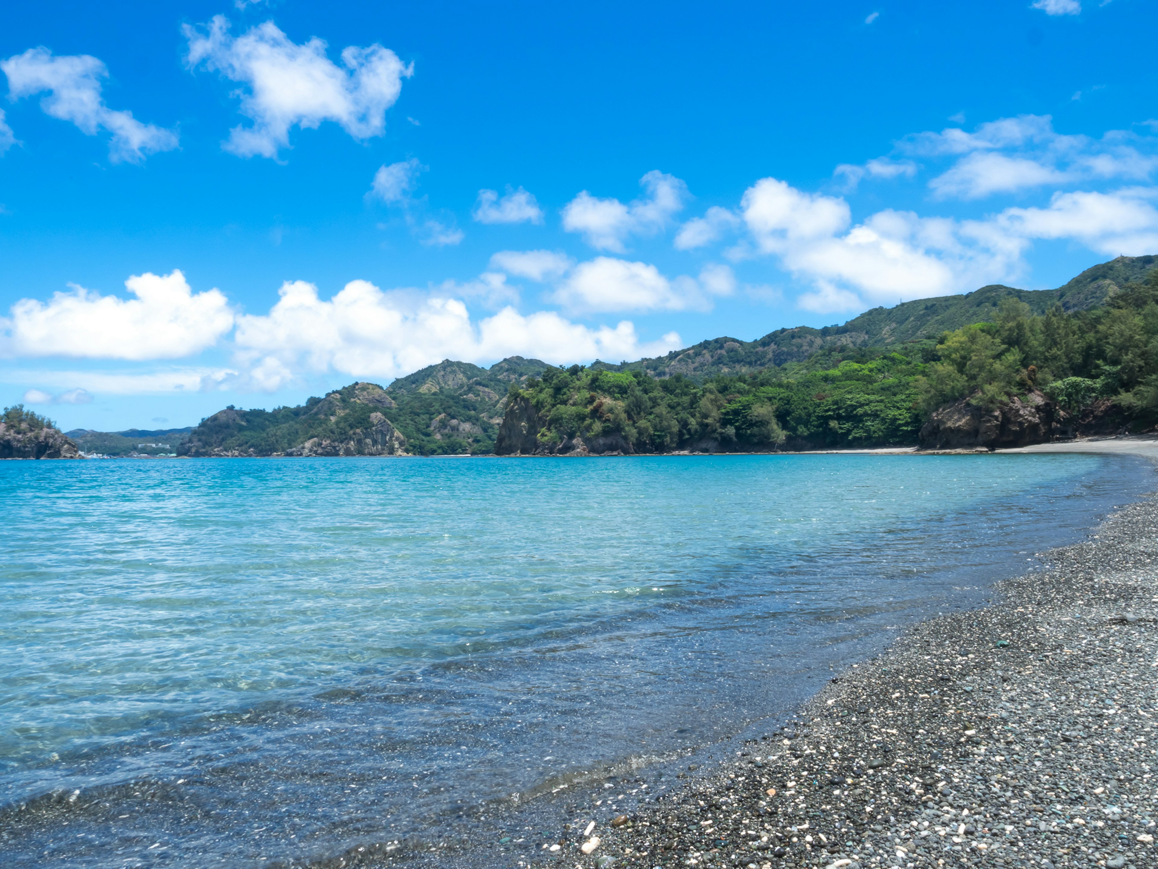 Malersicher Blick auf einen ruhigen Strand mit klarem Wasser und üppigem Grün