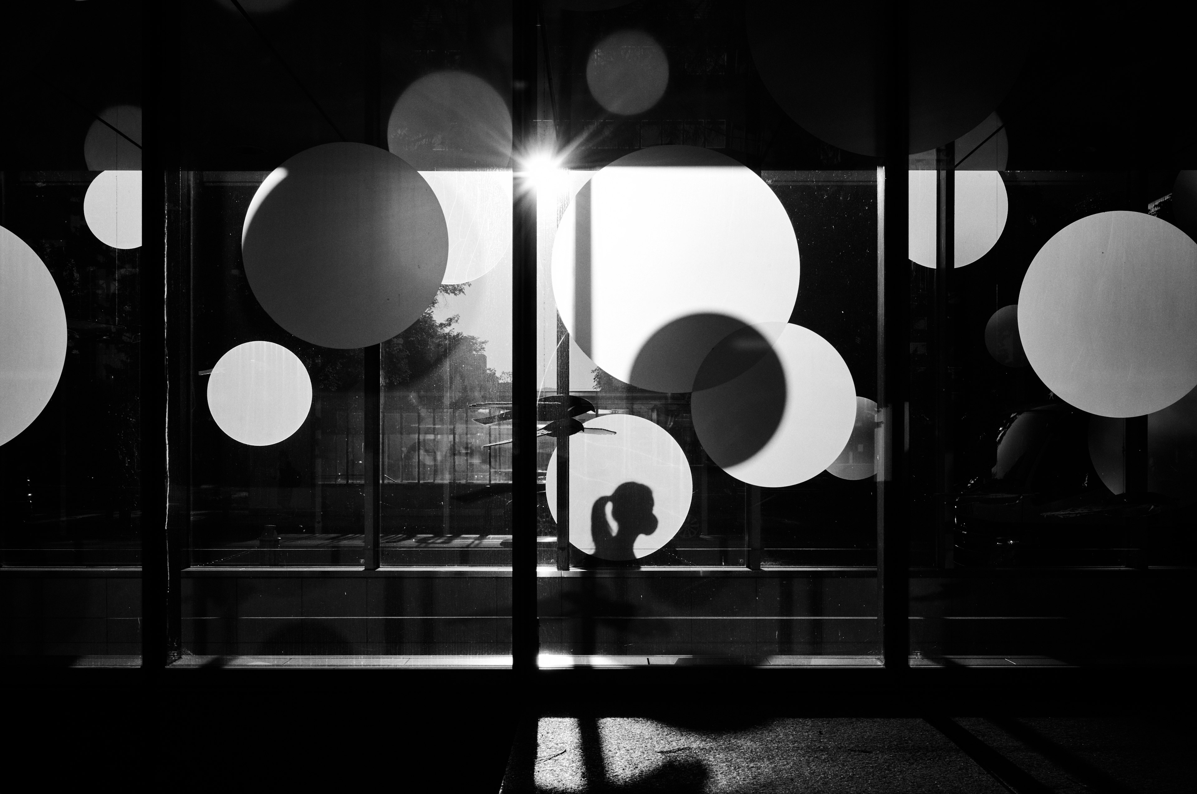 Silhouette against a backdrop of large circular designs in black and white