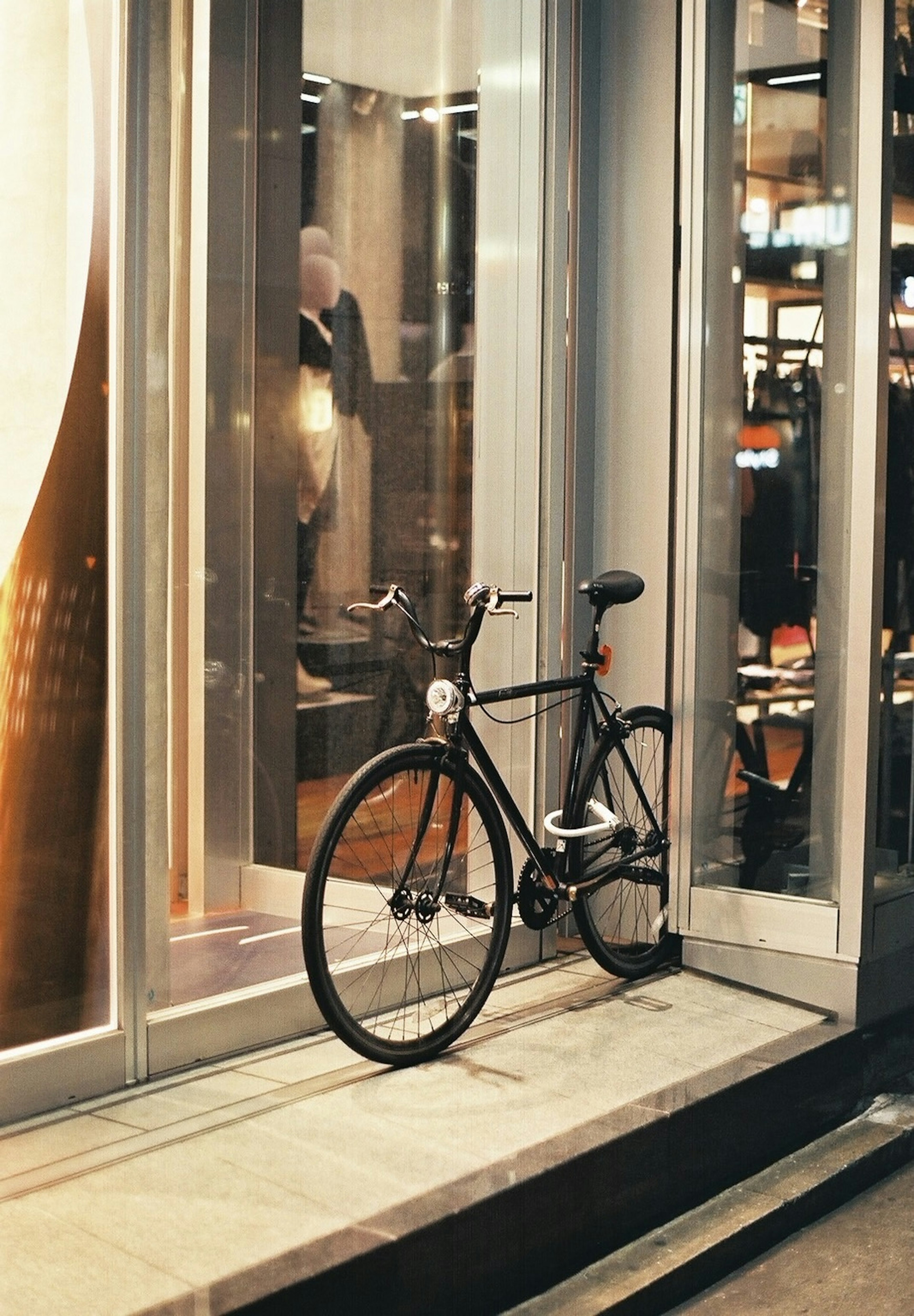 Una bicicleta negra estacionada junto a una vitrina de vidrio