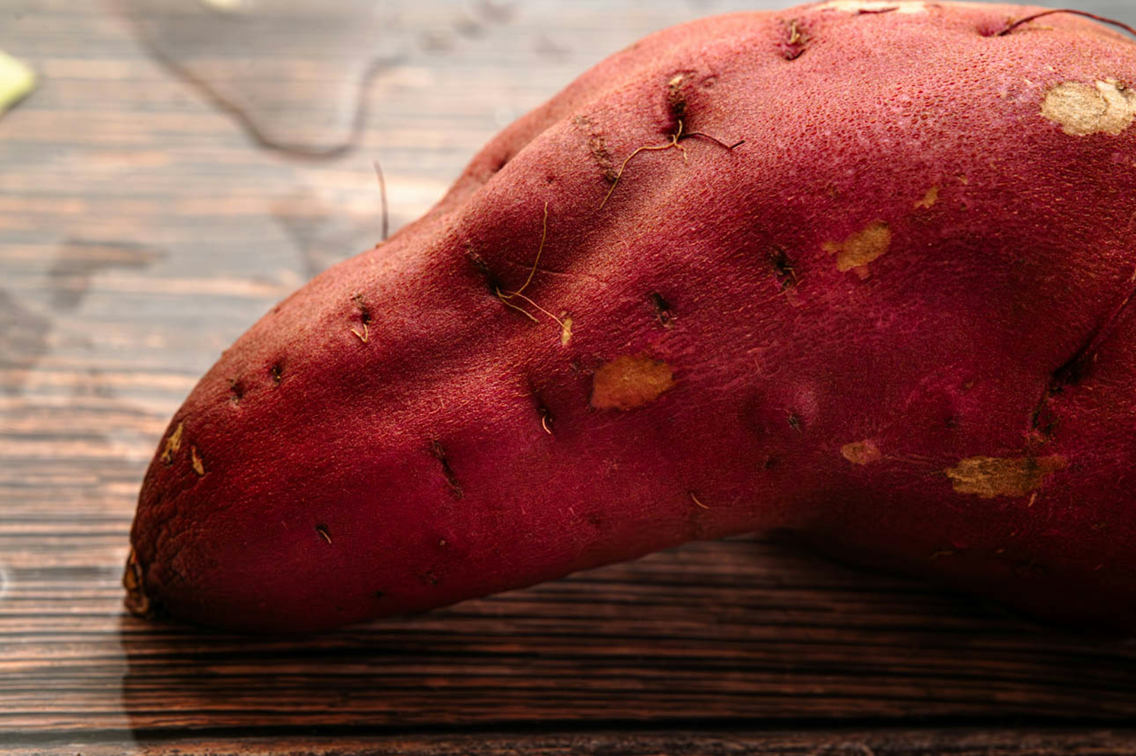 A red sweet potato placed on a wooden table