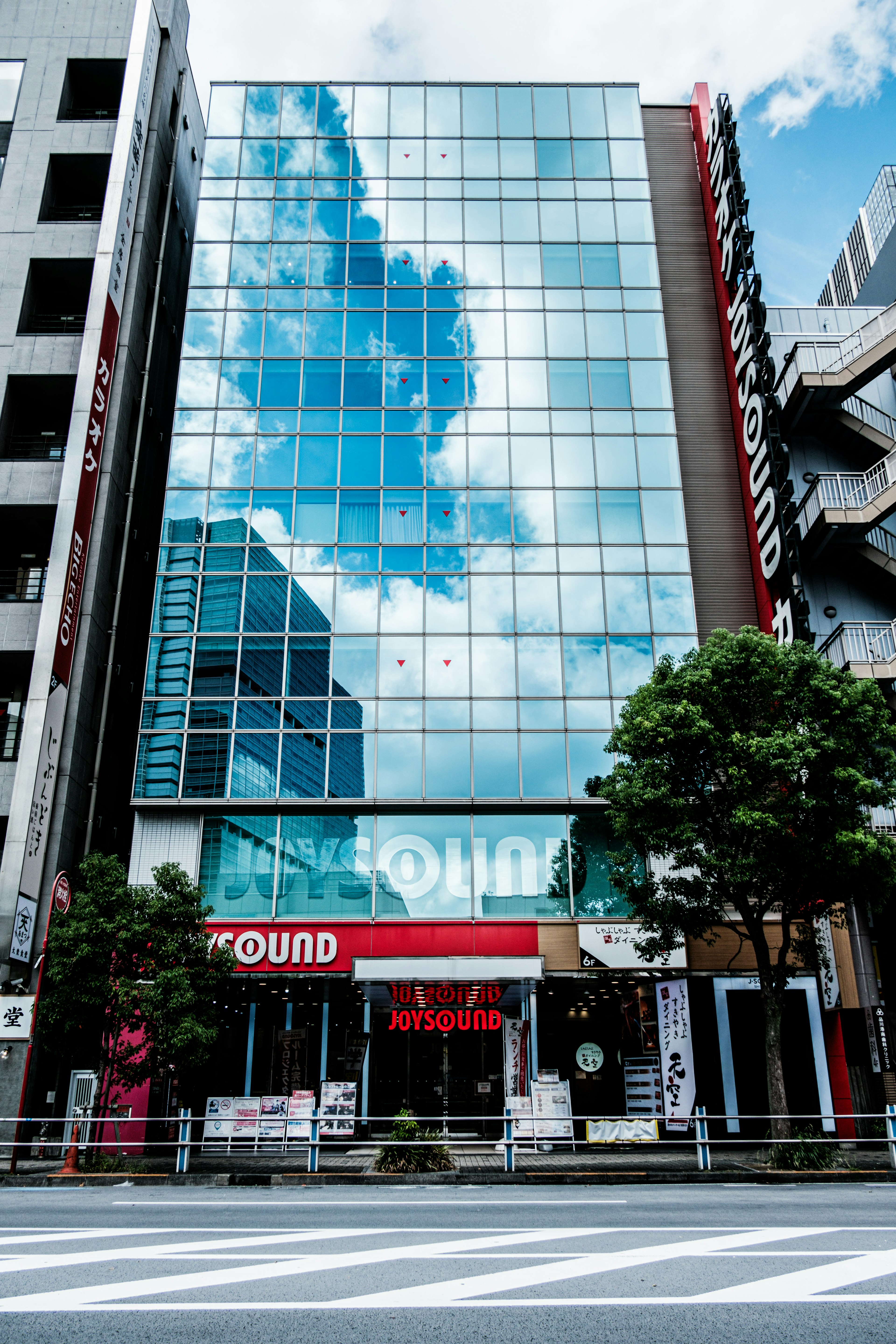 Modern glass building reflecting the sky and clouds