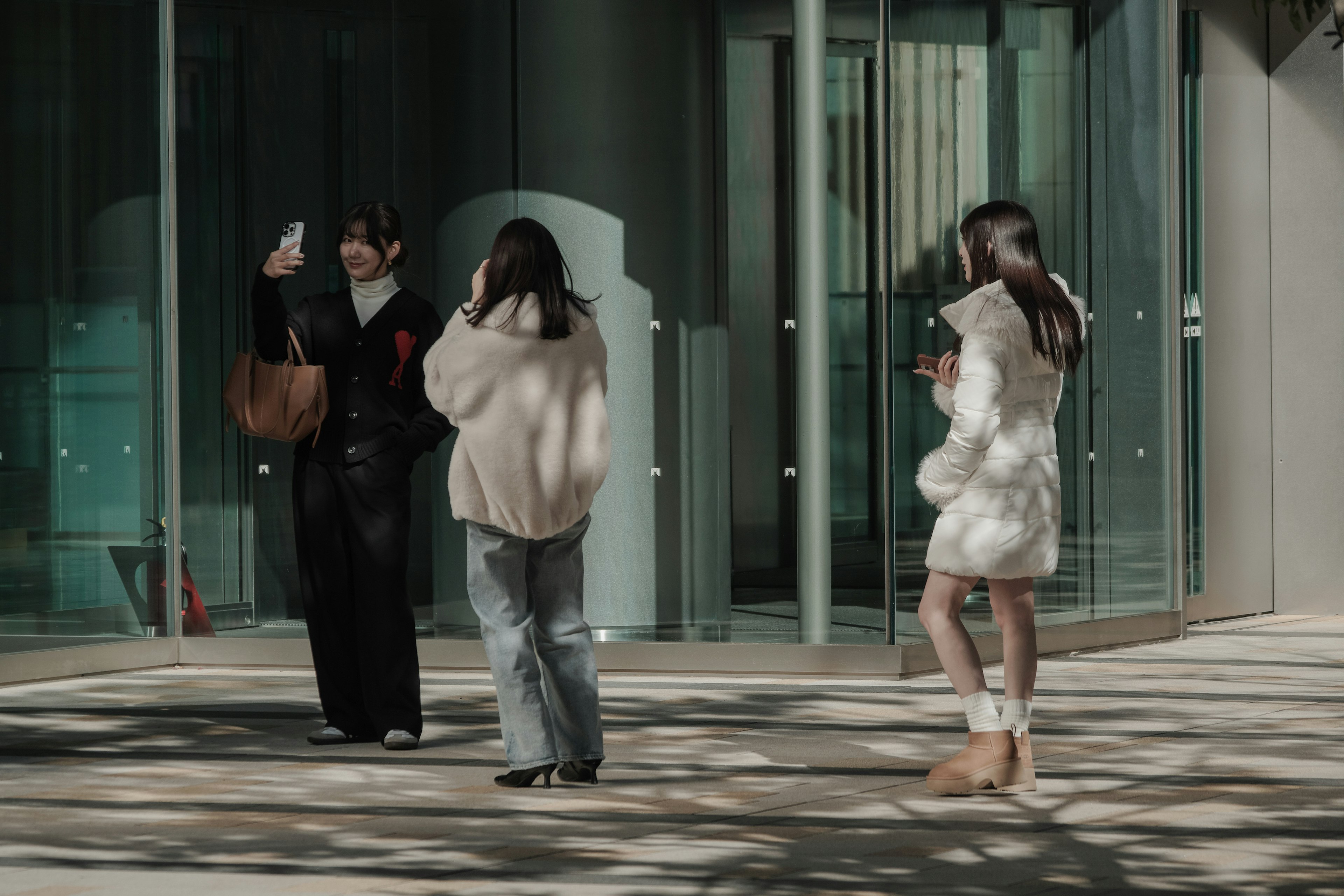 Mujeres tomando selfies frente a un edificio moderno