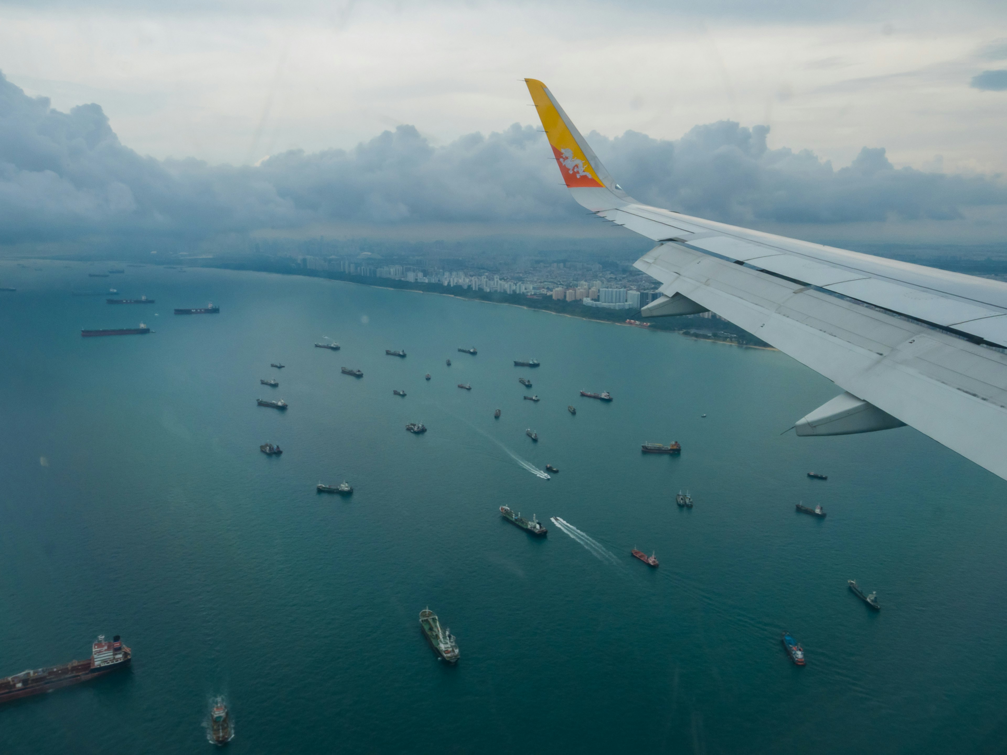 飛行機の翼から見た海と船の景色