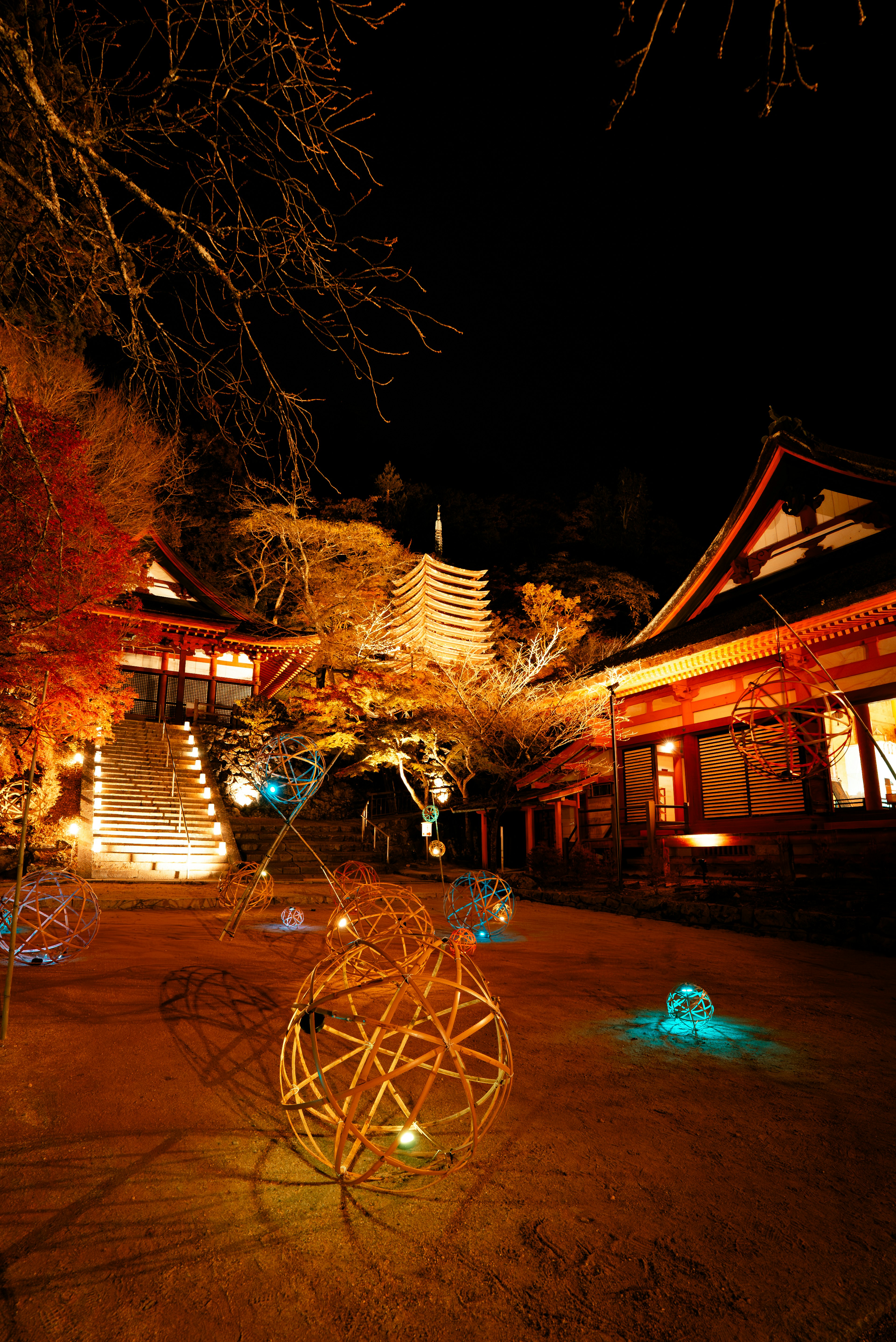 夜の寺院の庭に灯る色とりどりのライトと伝統的な建物