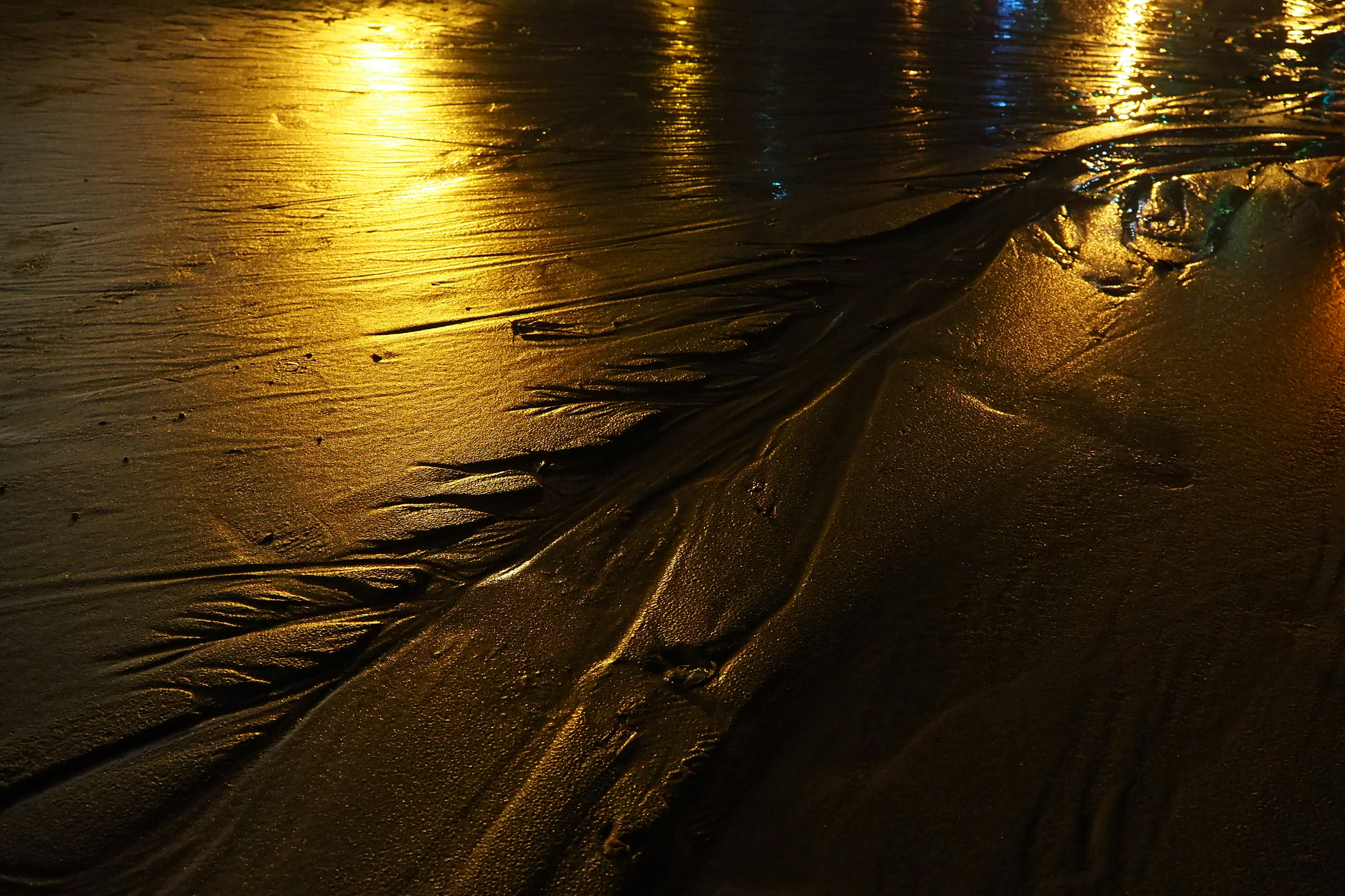 Textura de carretera mojada reflejando las luces nocturnas