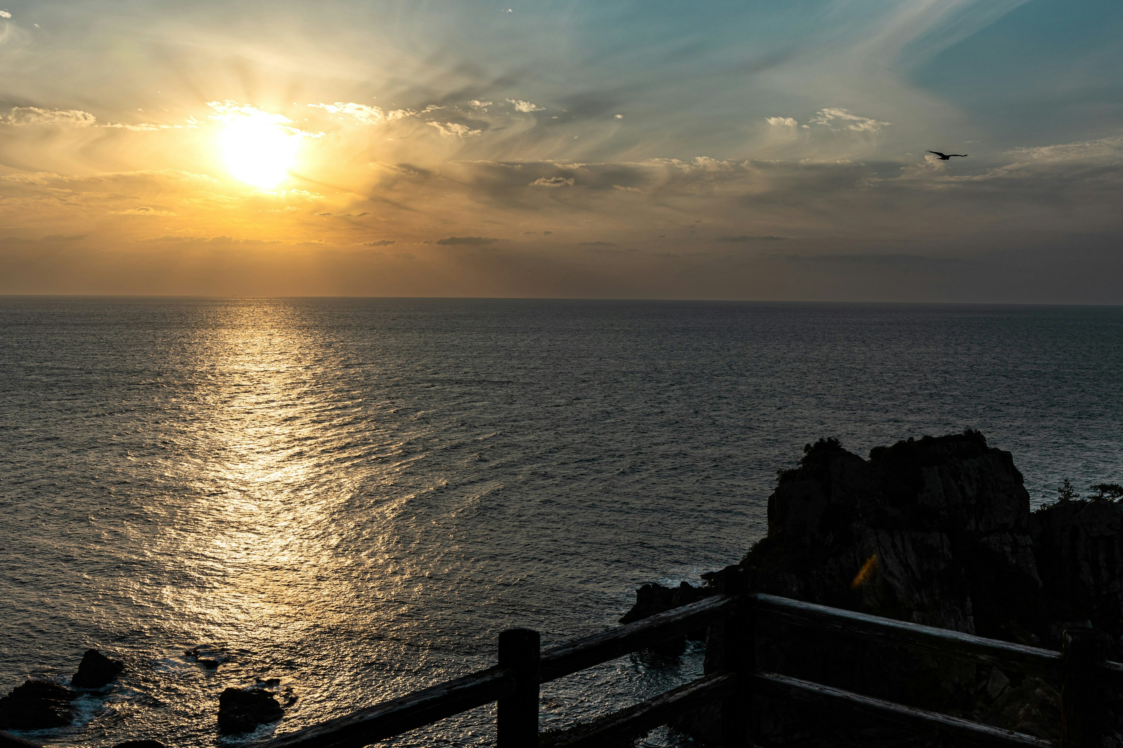 夕日が海に沈む美しい風景で岩が見える