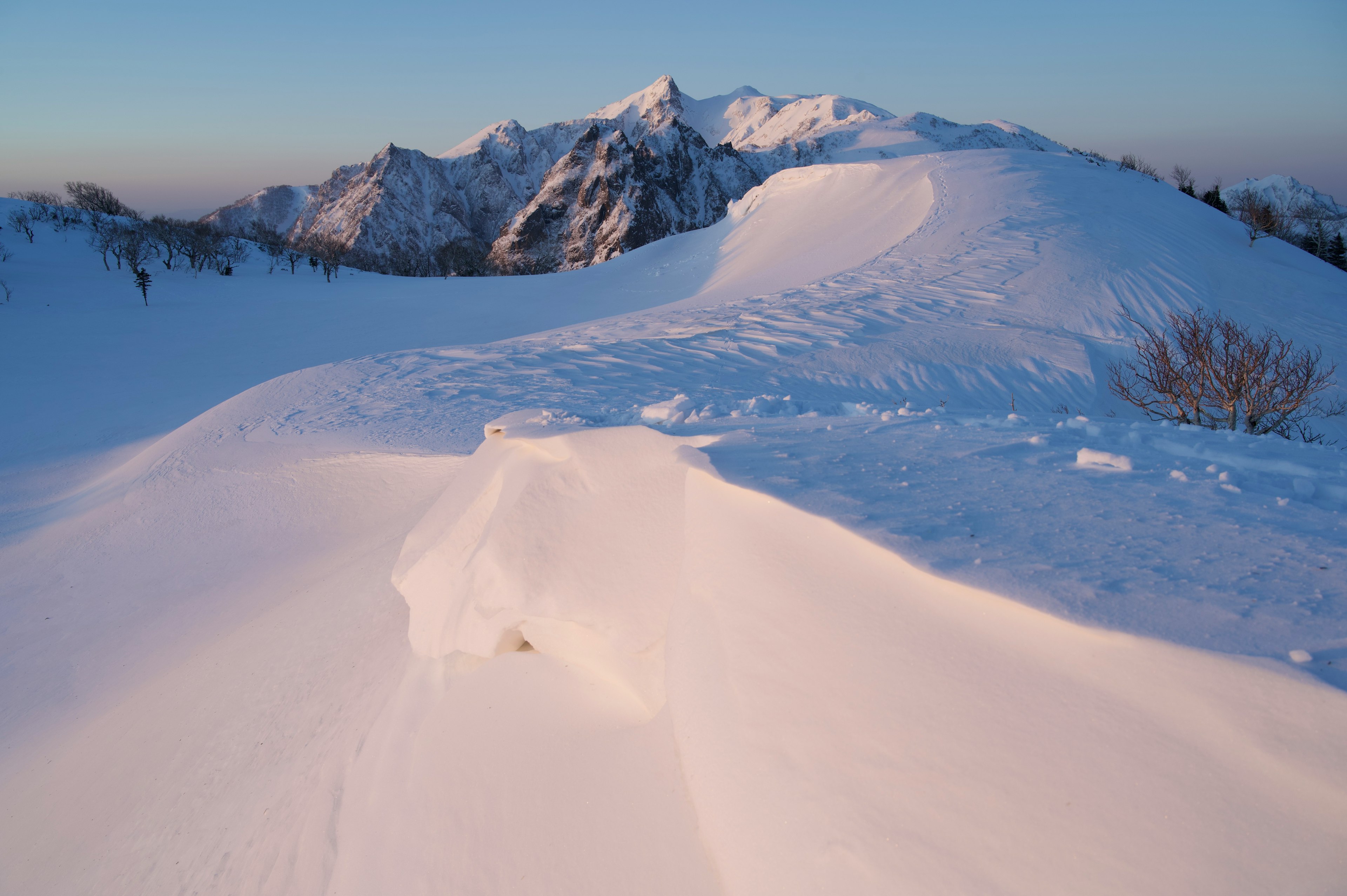 Snow-covered mountain landscape with a clear blue sky