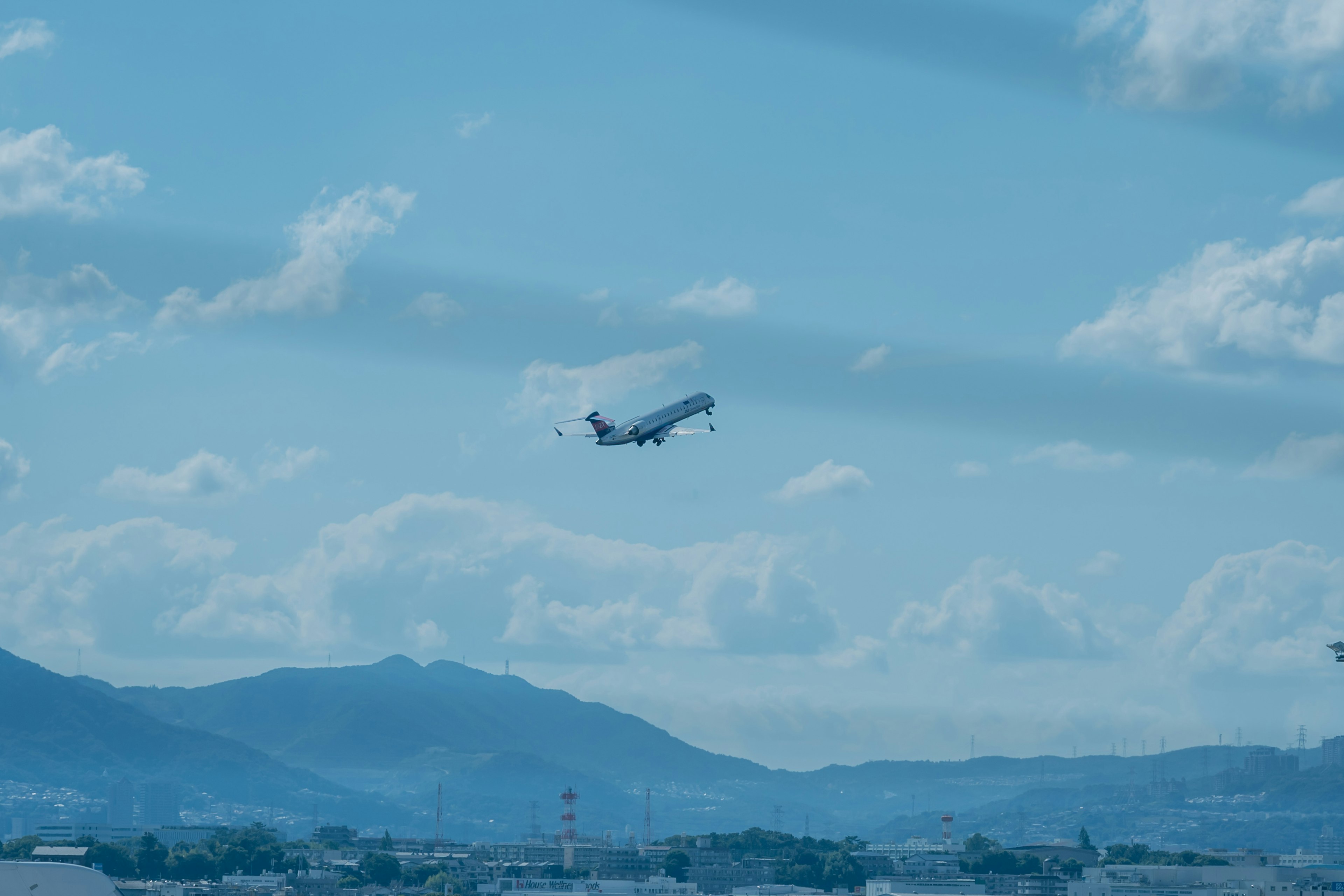 Avión despegando contra un cielo azul y montañas