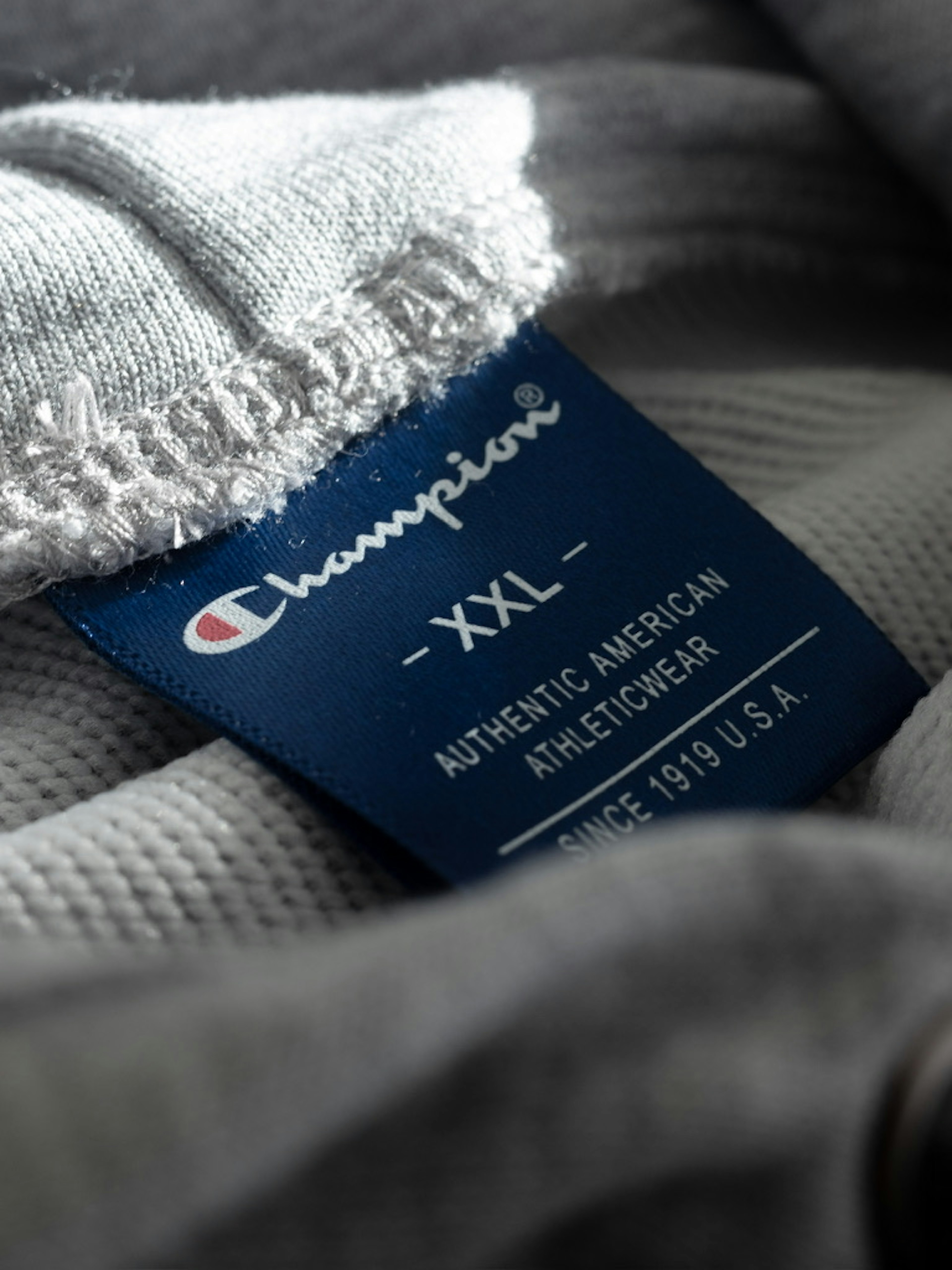 Nahaufnahme eines XXL-Labels von Champion auf einem Kleidungsstück