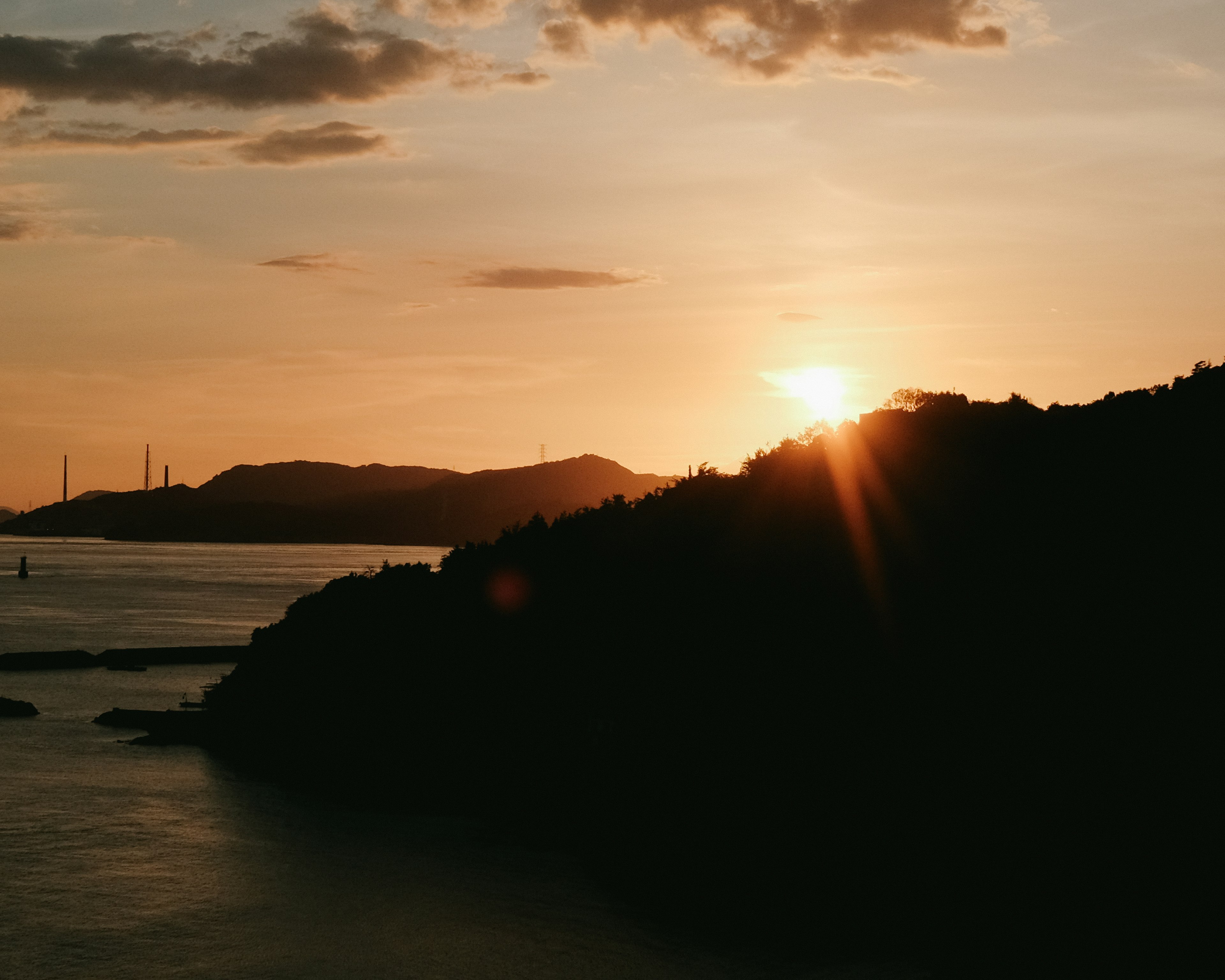 Beautiful landscape of sunset rising between mountains orange gradient in sky and sea