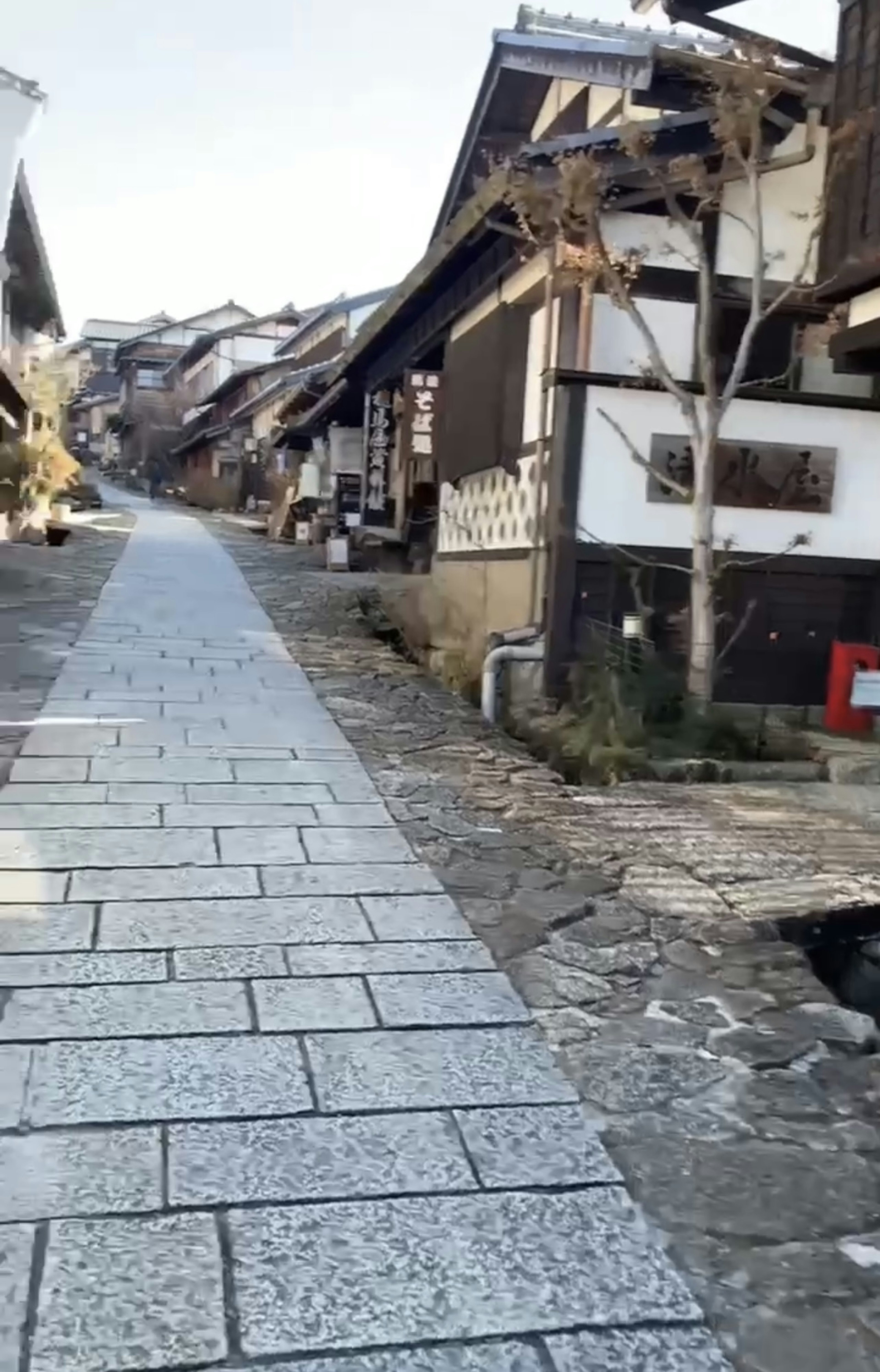 Camino pavimentado de piedra tranquilo bordeado de casas de madera tradicionales