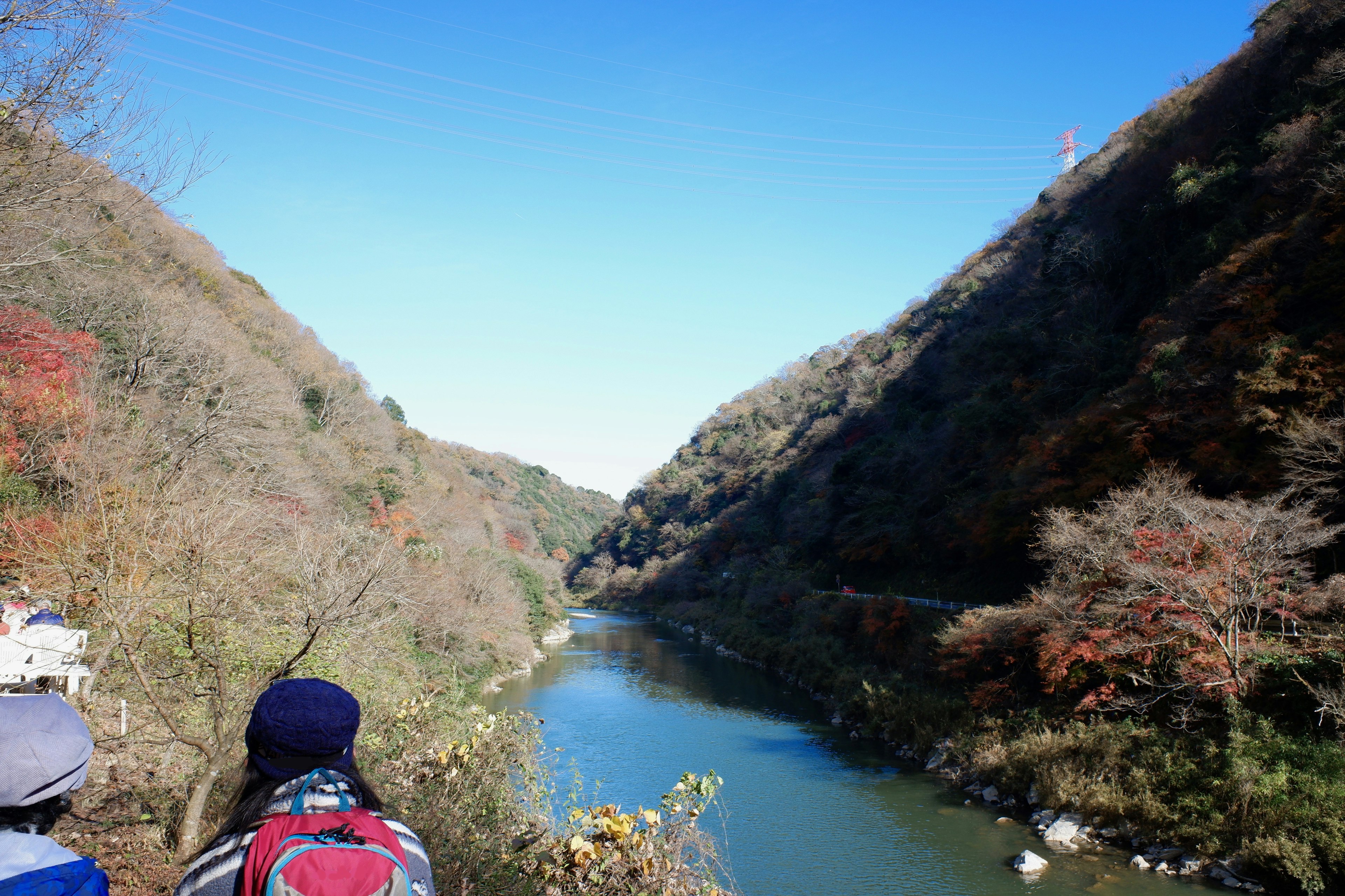 Silhouettes de personnes regardant une vallée et une rivière sous un ciel bleu