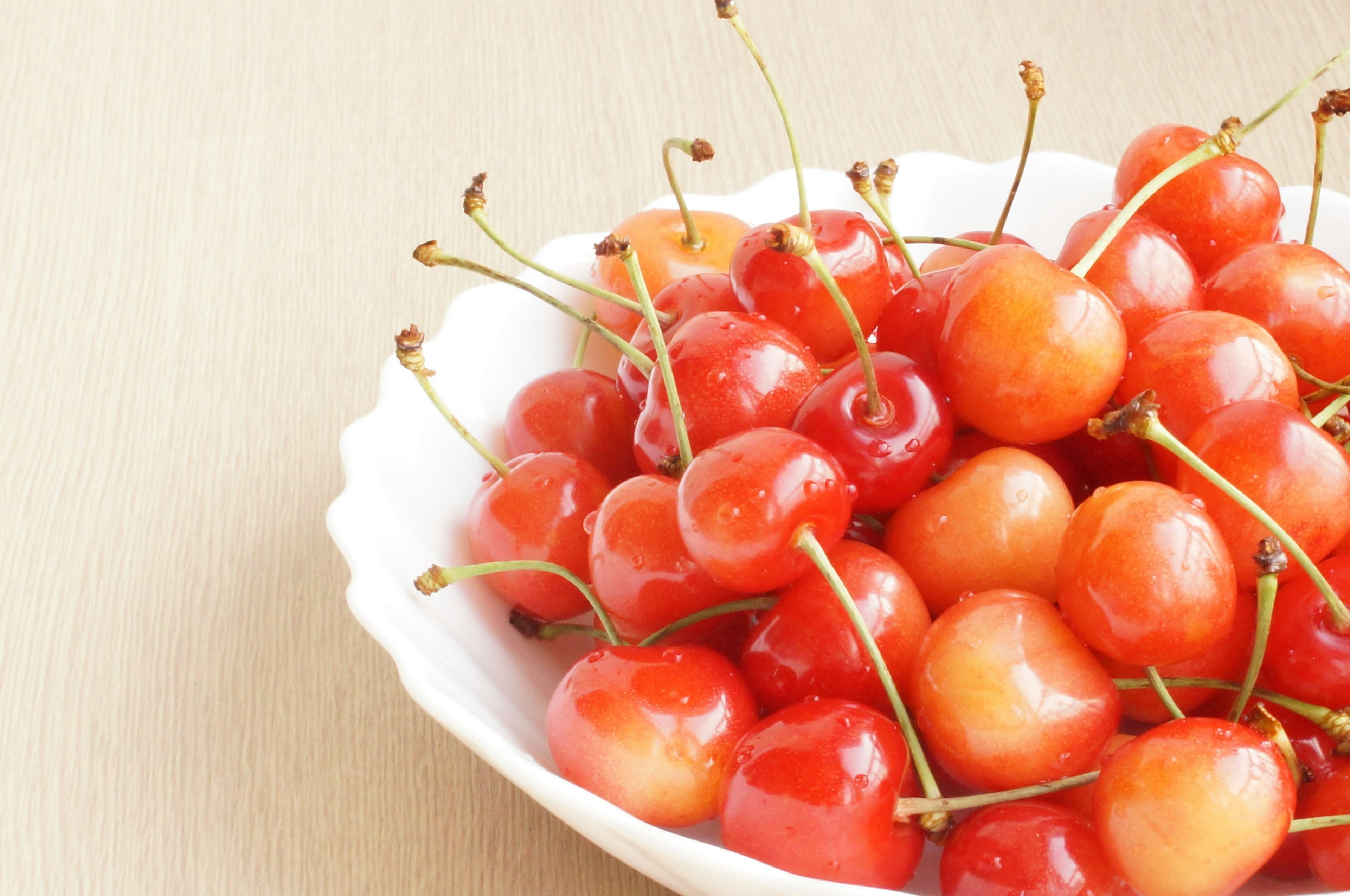 A mound of red cherries in a white bowl